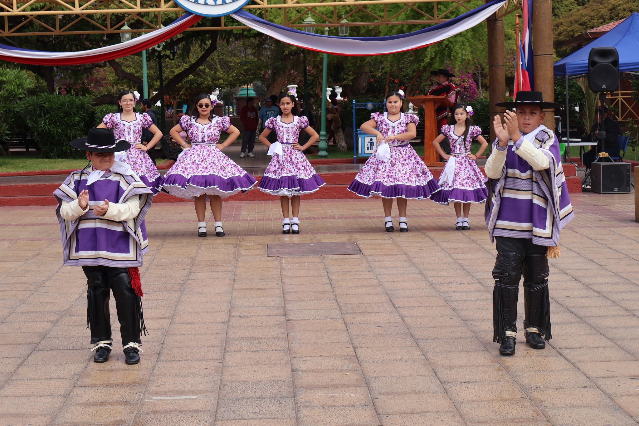 Agrupación folclórica infantil bailando cueca en la Plaza de Armas durante el Masivo Ciudadano 2025 en Taltal.