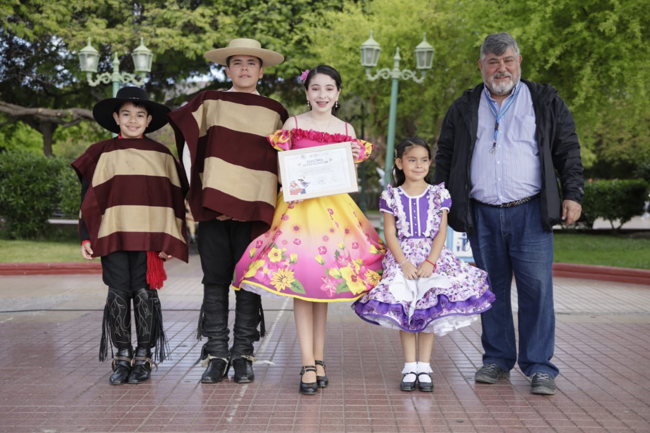 Niños y niñas reciben reconocimiento tras su presentación en el Masivo de Cueca Ciudadana 2025 en la Plaza de Armas de Taltal.