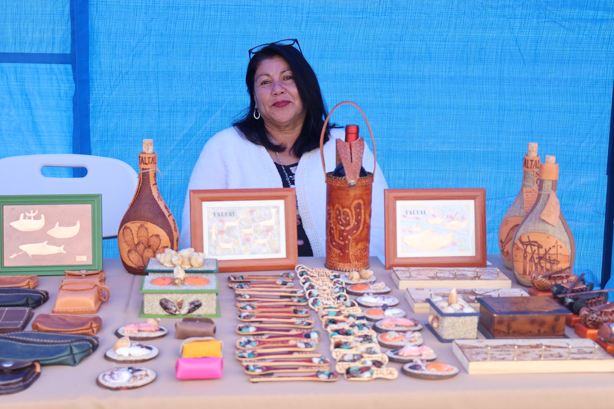 Artesana taltalina exhibe trabajos en cuero, botellas recicladas y cuadros inspirados en la identidad costera local durante AgroTaltal 2025.