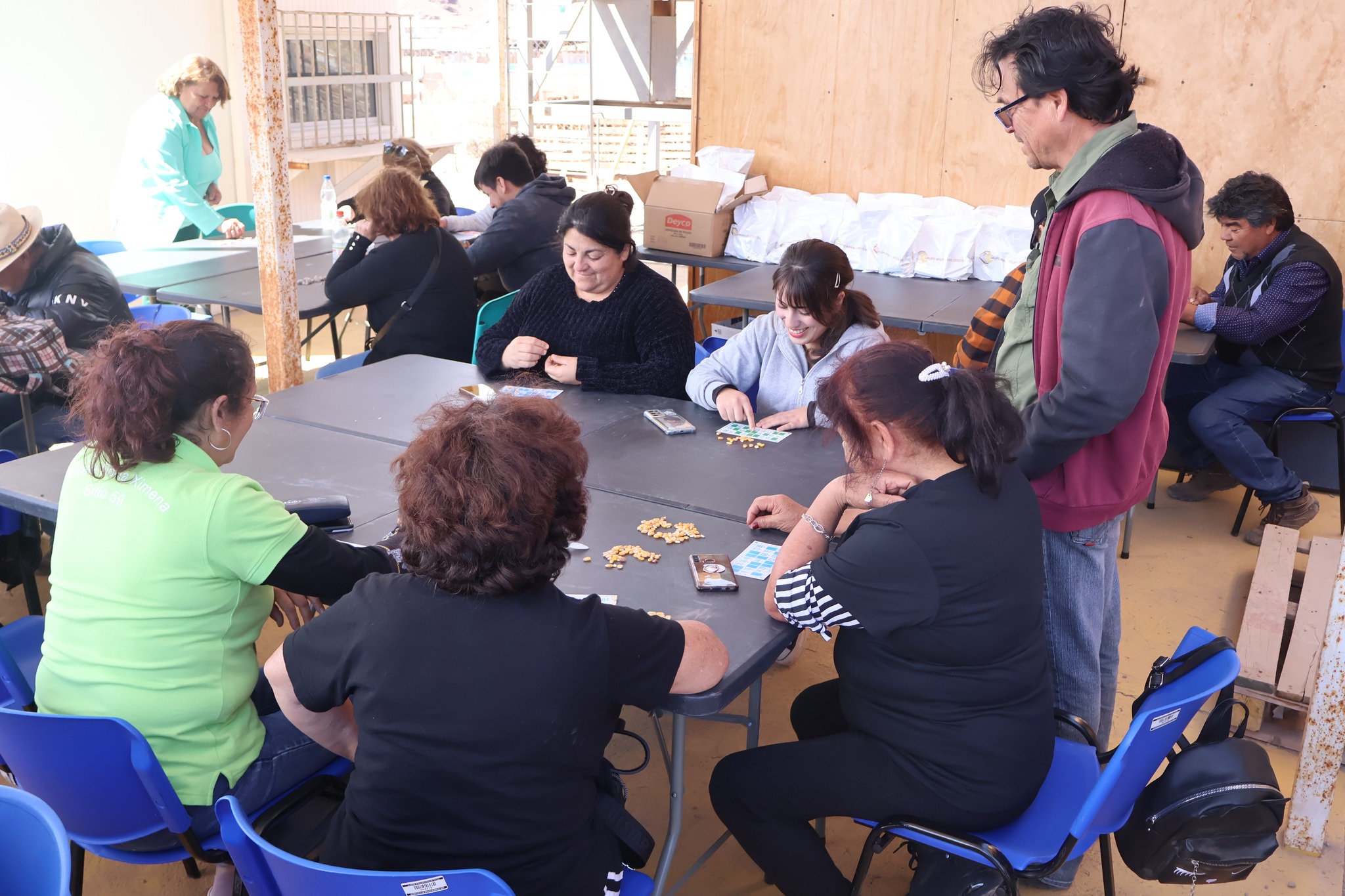 Familias y adultos mayores compartiendo en torno a la Lota Comunitaria de AgroTaltal 2025, en La Cachina.