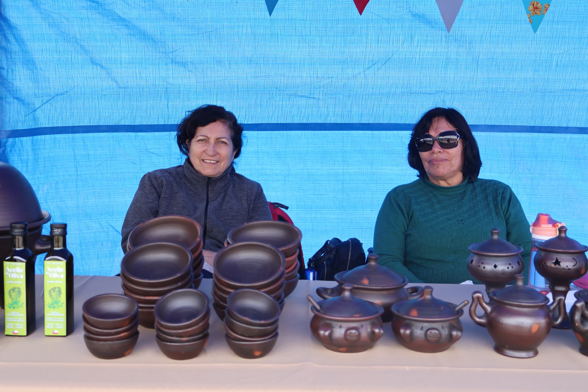 Productoras taltalinas exponen artesanía en greda y cerámica junto a aceites de oliva locales.