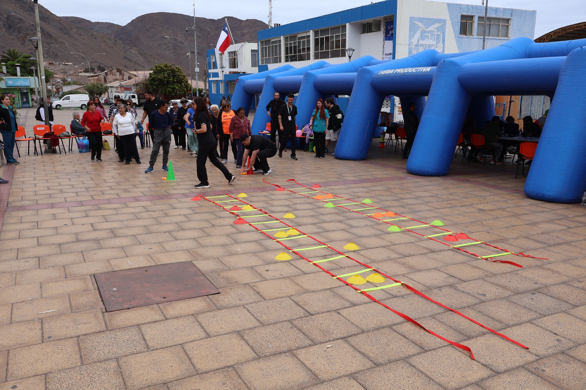 Mujer adulta mayor con anteojos sonriendo y caminando en la marcha con un globo azul.
