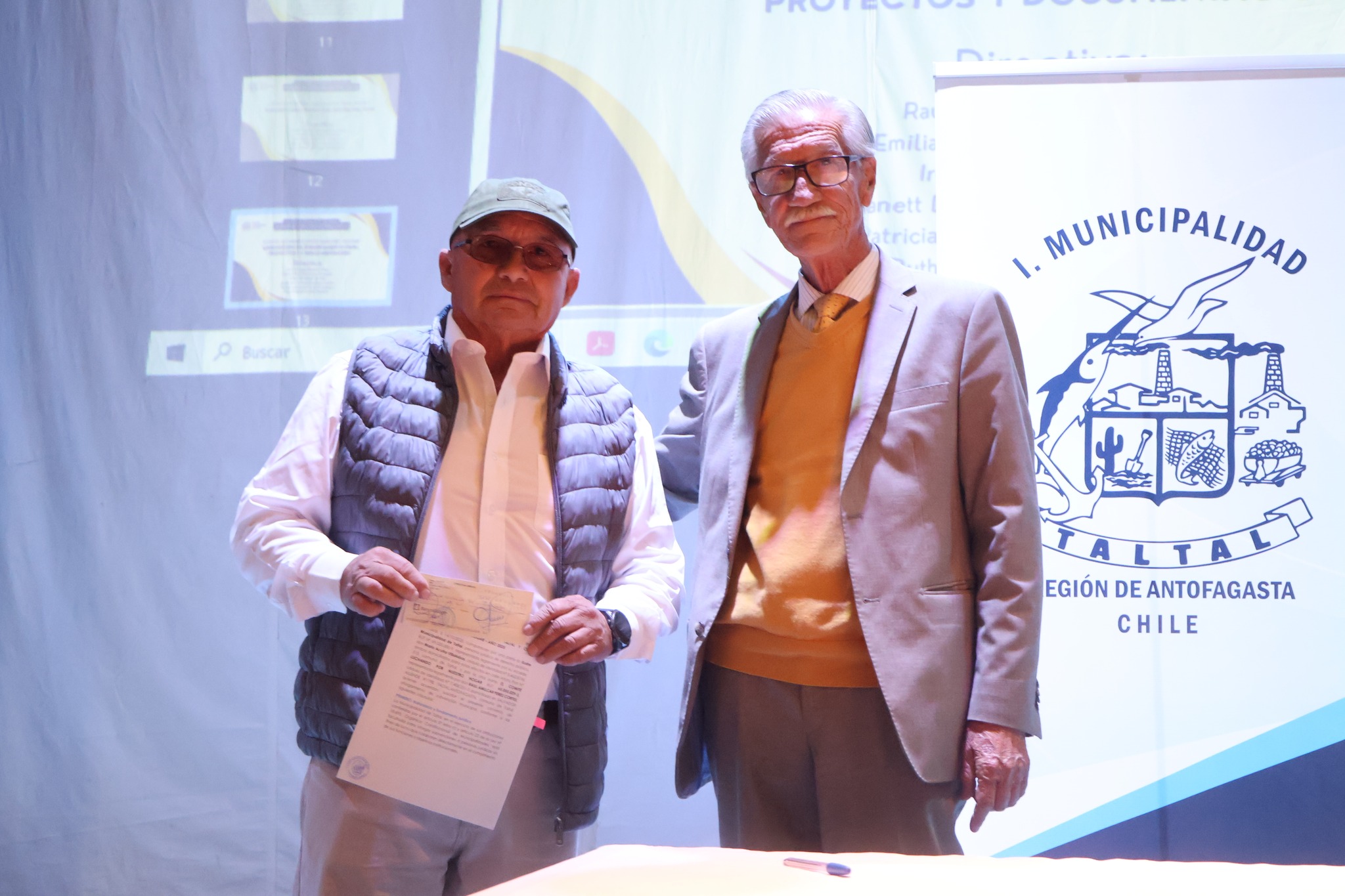 Autoridad comunal junto a dirigente durante ceremonia de subvenciones municipales en Taltal.