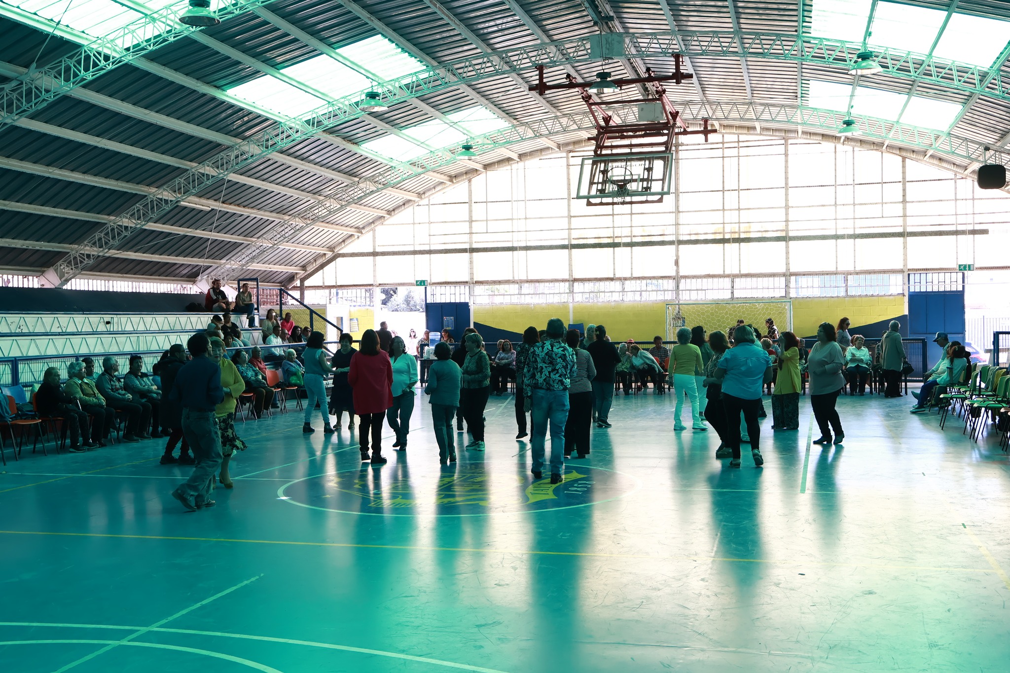 Vista general del Estadio Techado de Taltal con adultos mayores participando en actividades recreativas y de baile.