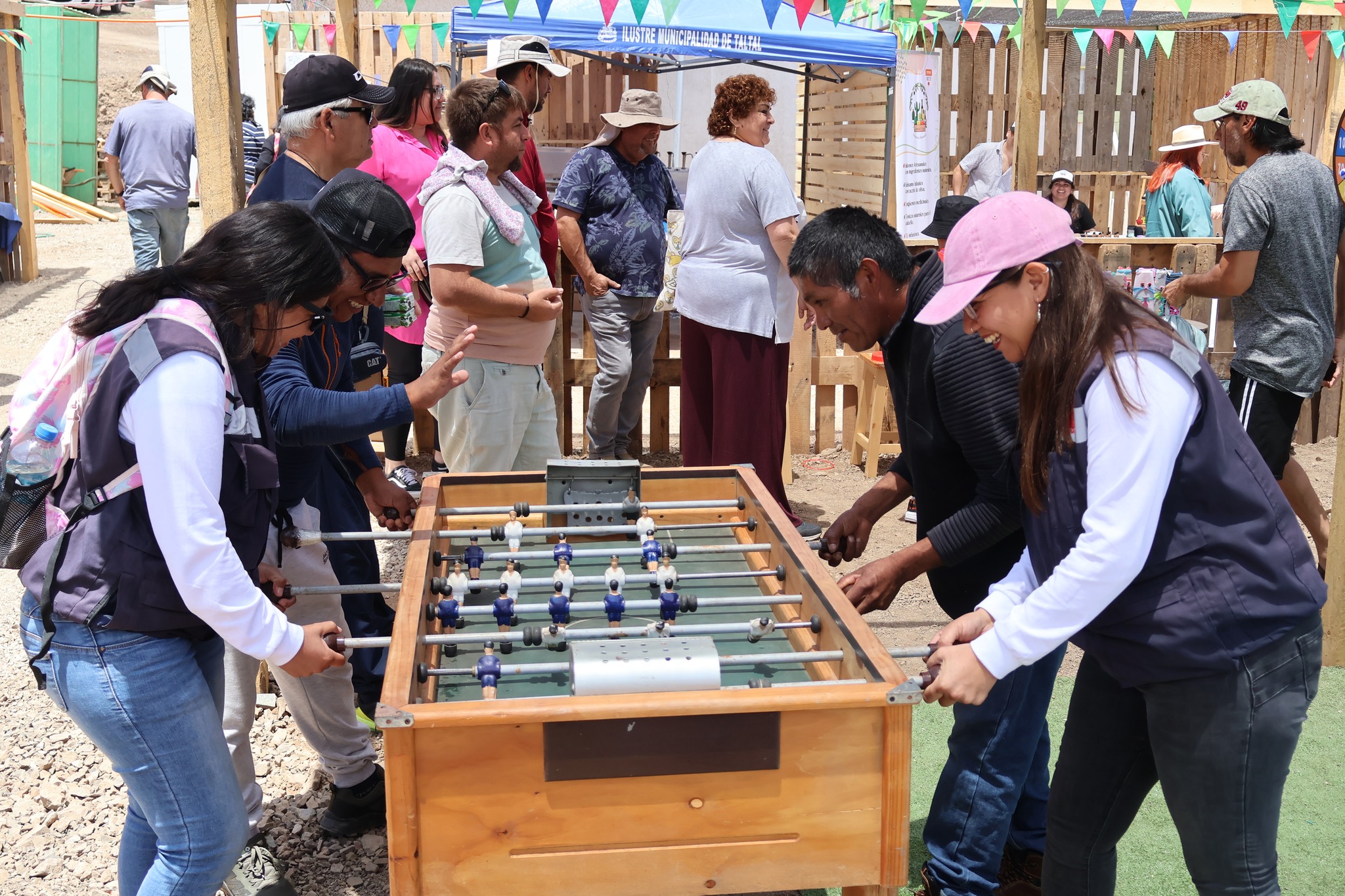 Vecinos disfrutan partidas de taca-taca en el sector de juegos tradicionales de la feria en Los Loros.