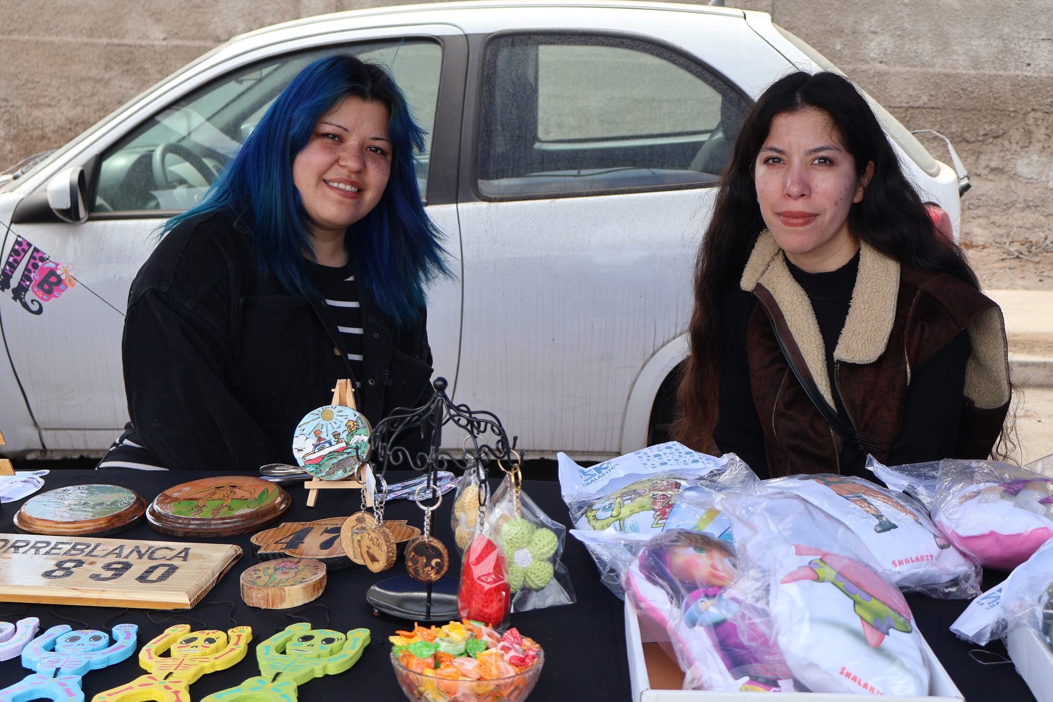 Dos emprendedoras exhiben productos decorativos y artesanías personalizadas en la feria comunal.