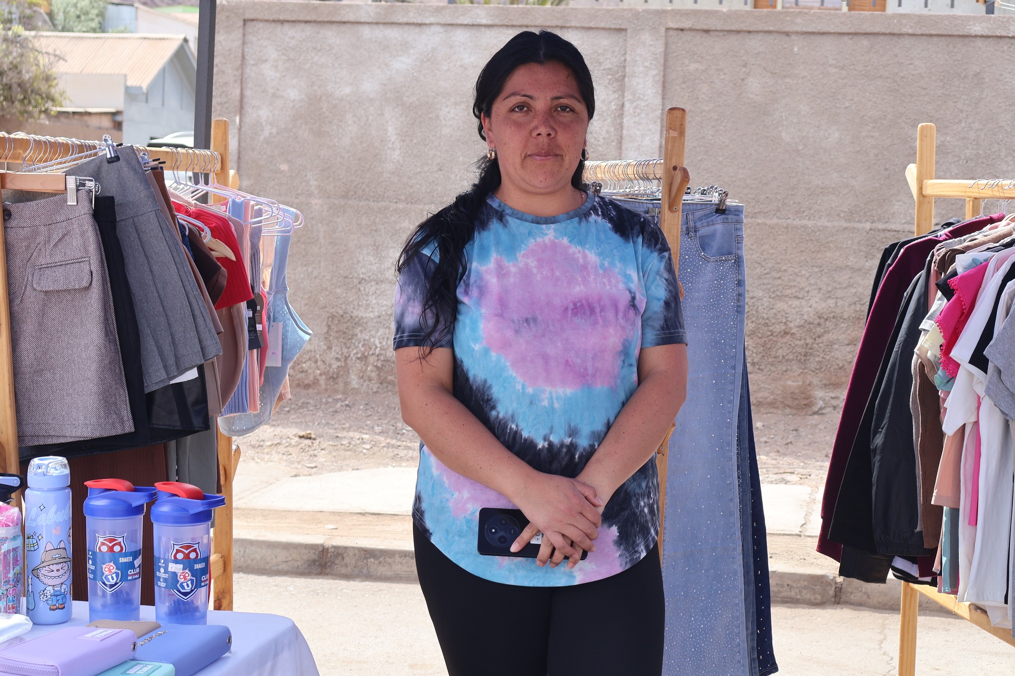 Expositora ofrece prendas de vestir y accesorios femeninos durante la Feria de Mujeres Emprendedoras en Taltal.