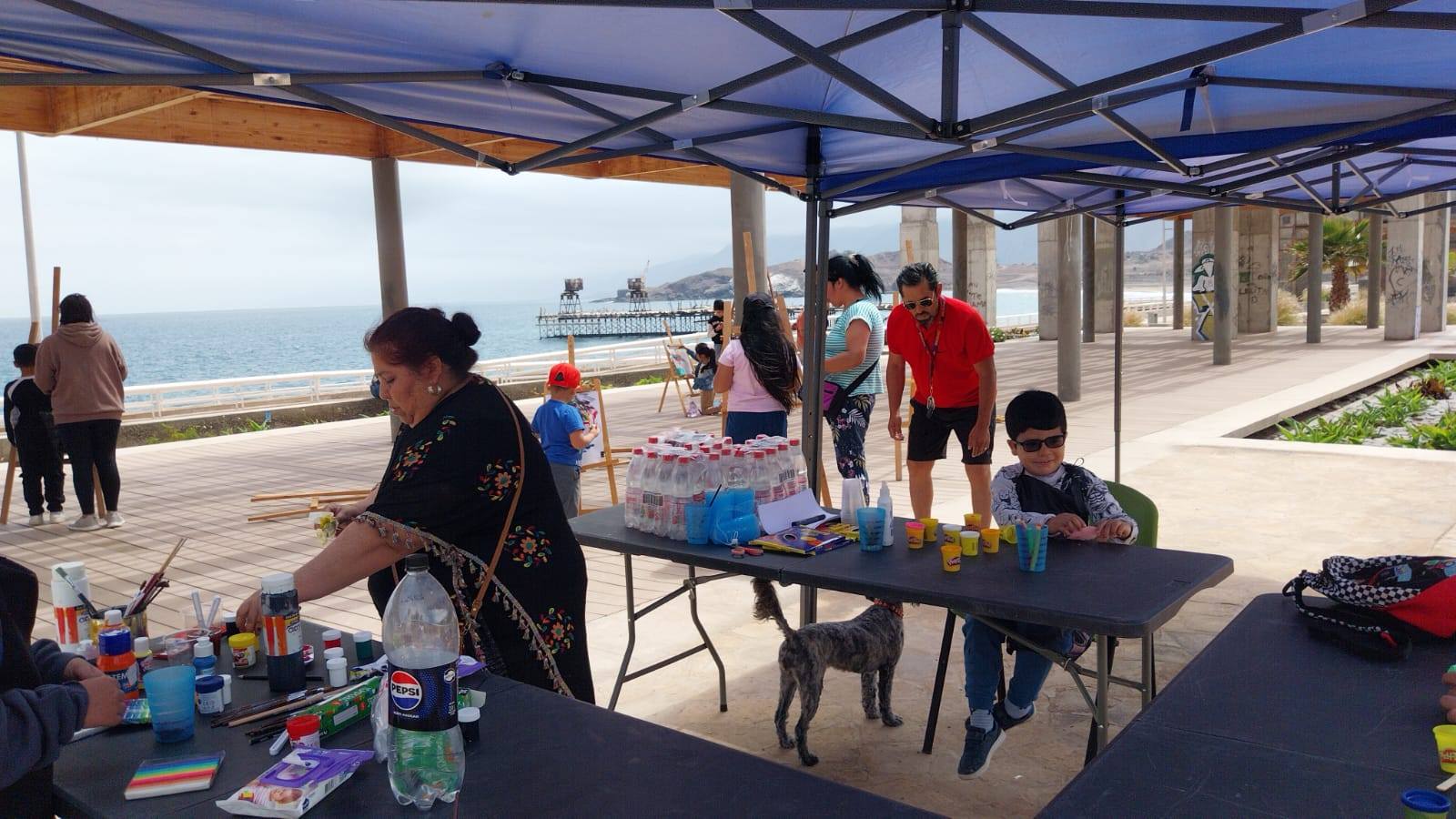 Taller de pintura comunitaria en el borde costero de Taltal, con la participación de niños y adultos.