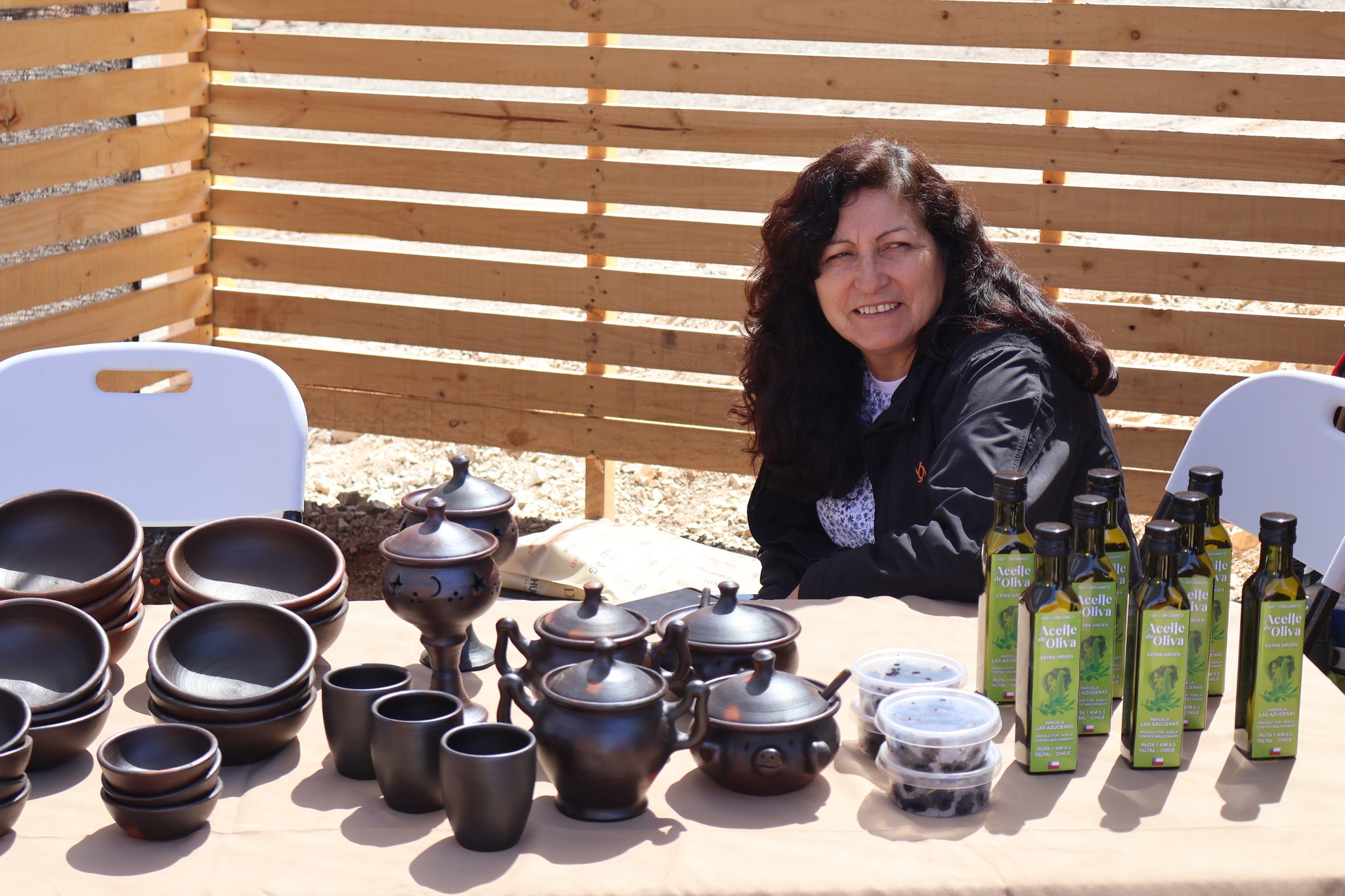 Artesana taltalina exhibe piezas de greda y aceite de oliva en su stand durante la feria costumbrista