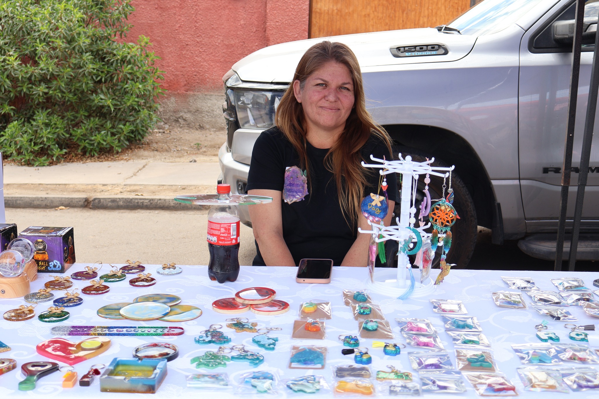 Emprendedora taltalina muestra colgantes y llaveros de resina hechos a mano en su stand.