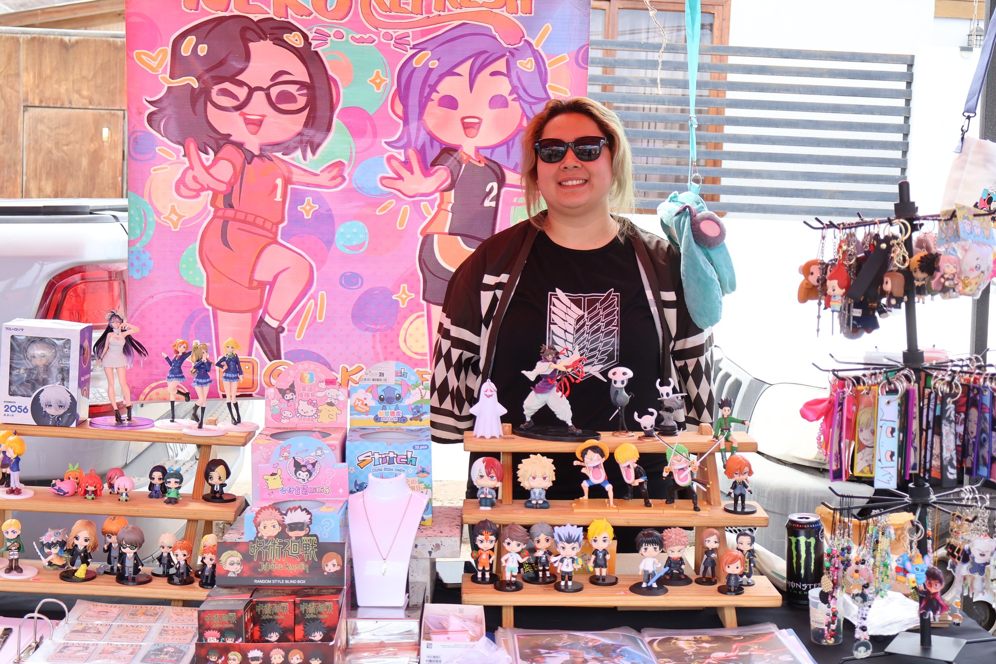 Stand con figuras coleccionables y productos de cultura anime atendido por emprendedora local.