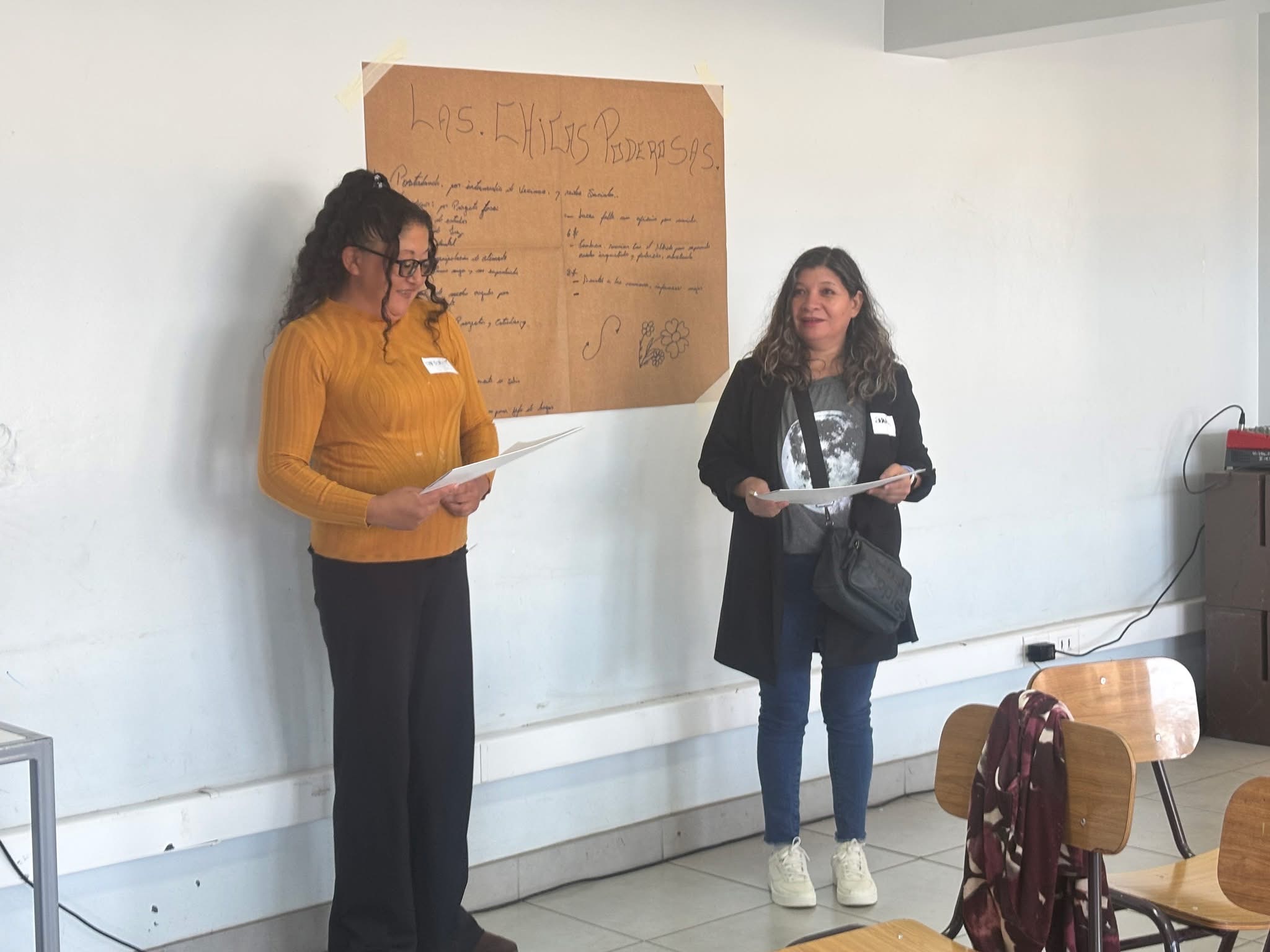 Dinámica grupal de participantes con exposición de trabajos en mural.