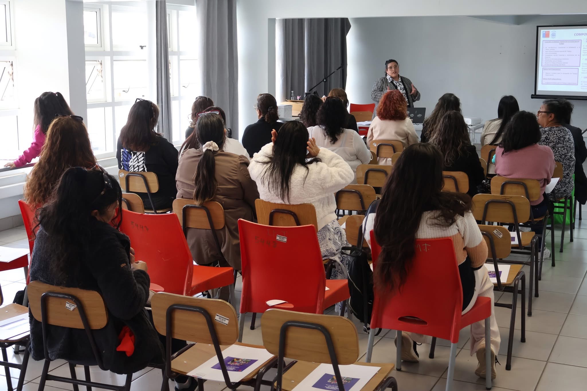 Participantes escuchando presentación en el Encuentro Comunal de Mujeres Jefas de Hogar.