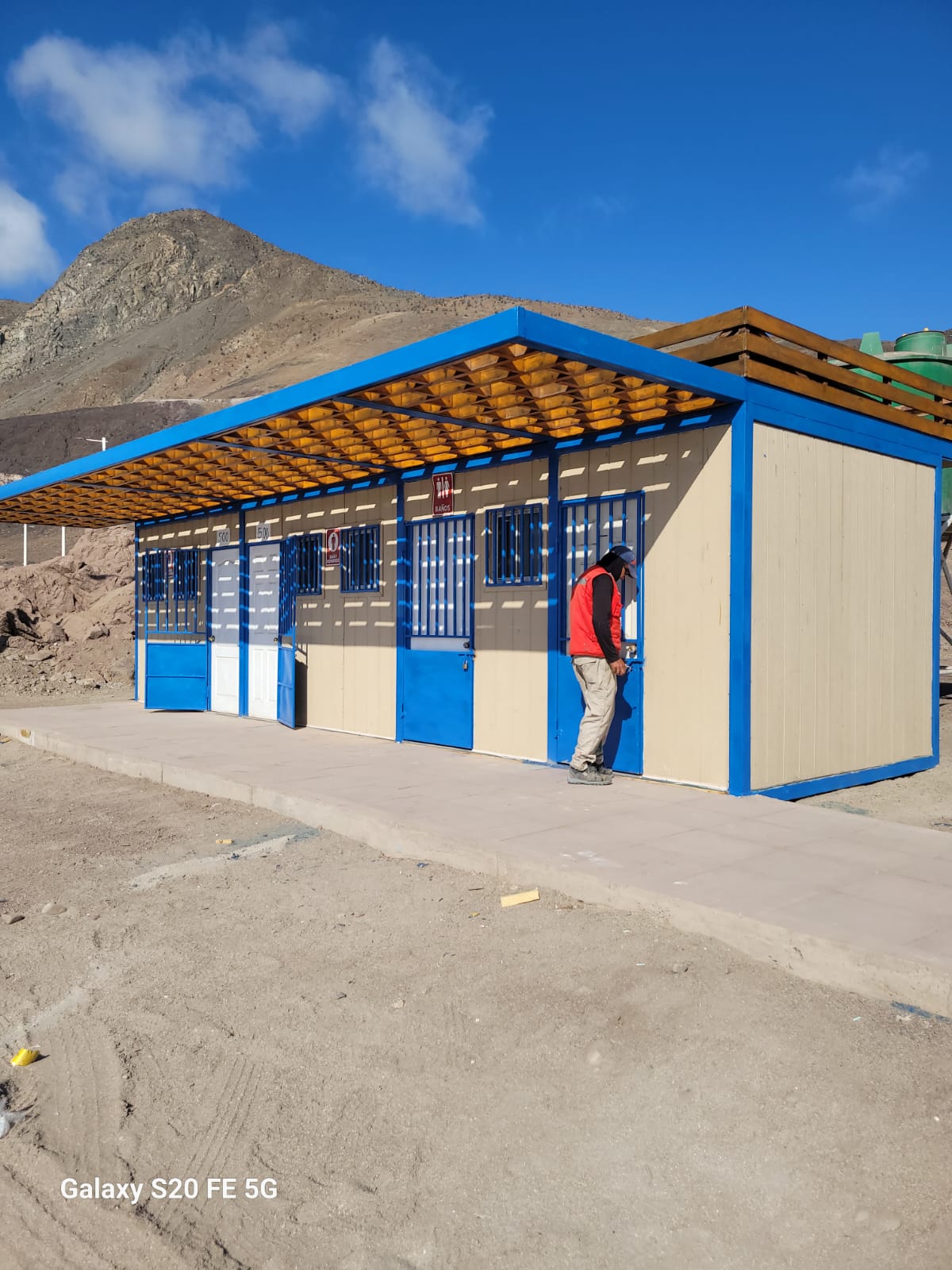 Trabajador municipal realiza mantenimiento de baños públicos en Playa Tierra del Moro, Taltal, como parte del plan de mejora de espacios costeros.