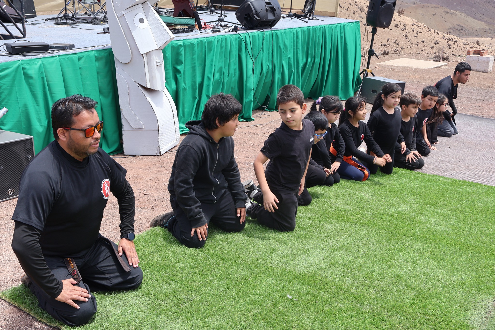 nstructor junto a alumnos del taller municipal de artes marciales cierran su presentación con saludo tradicional en El Hueso.