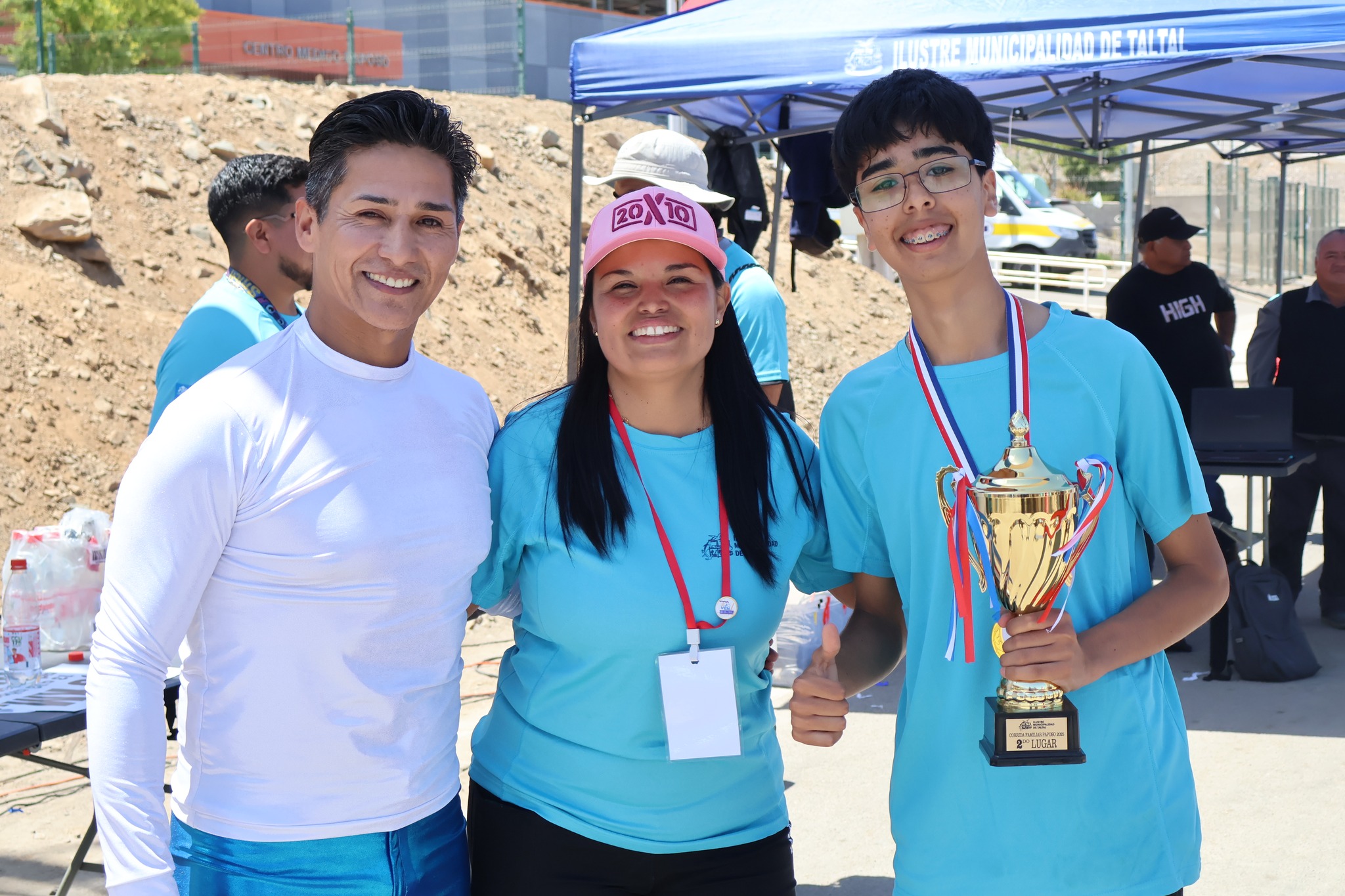 Joven participante recibe el trofeo del segundo lugar junto al equipo organizador en la Corrida Familiar de Paposo 2025.