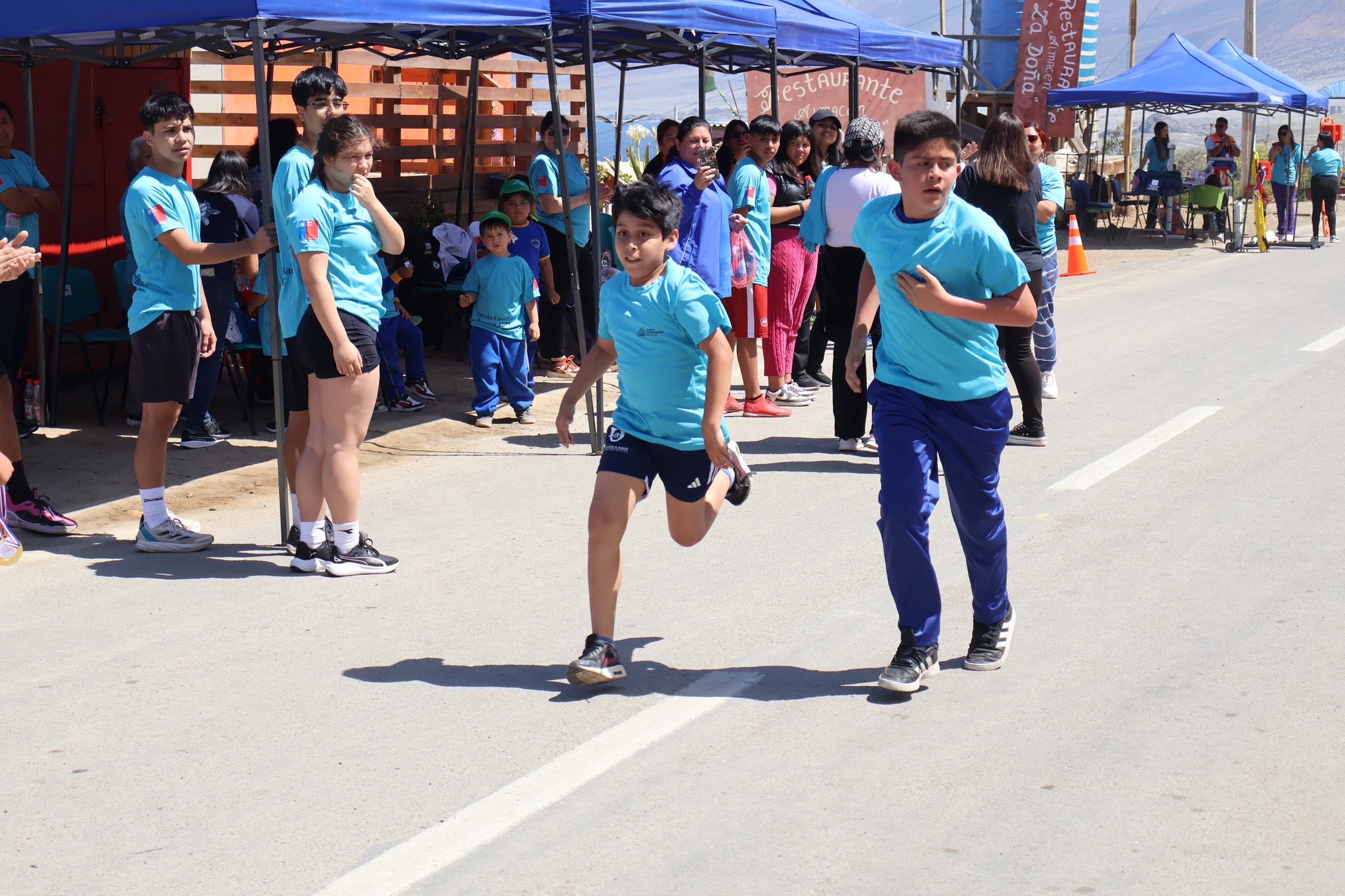 Niños participan con entusiasmo en la categoría infantil de la Corrida Familiar de Paposo 2025, bajo la mirada del público y monitores.