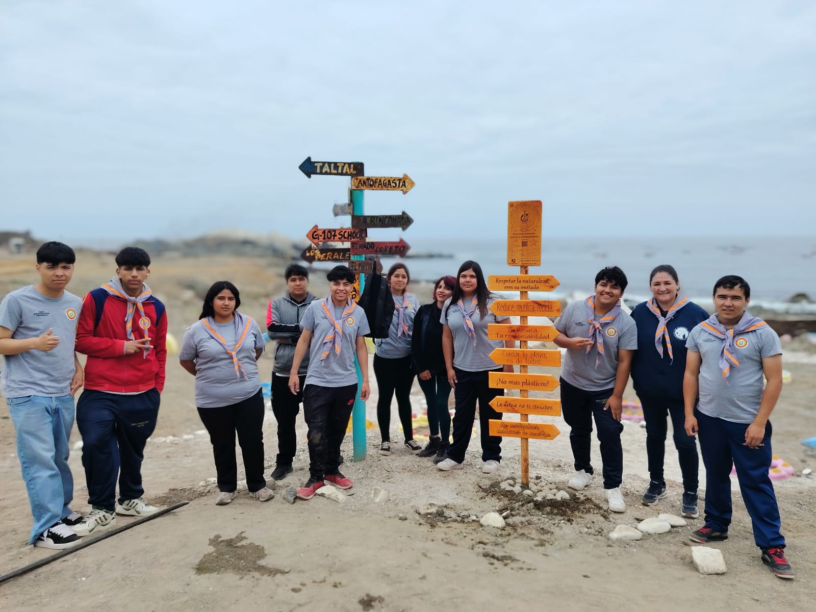 Estudiantes del Liceo Politécnico José Miguel Quiroz y equipo municipal instalando señalética ambiental en la playa de Paposo para promover el turismo sustentable en Taltal.