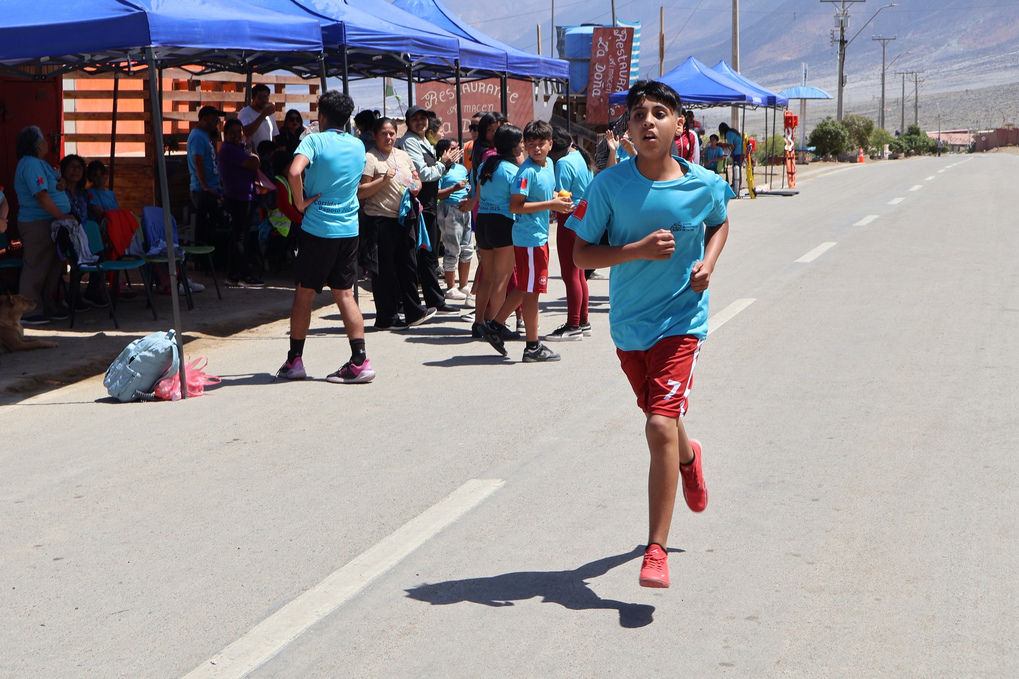 Niño participante corre por la calle principal de Paposo durante la primera Corrida Familiar organizada por la Municipalidad de Taltal.
