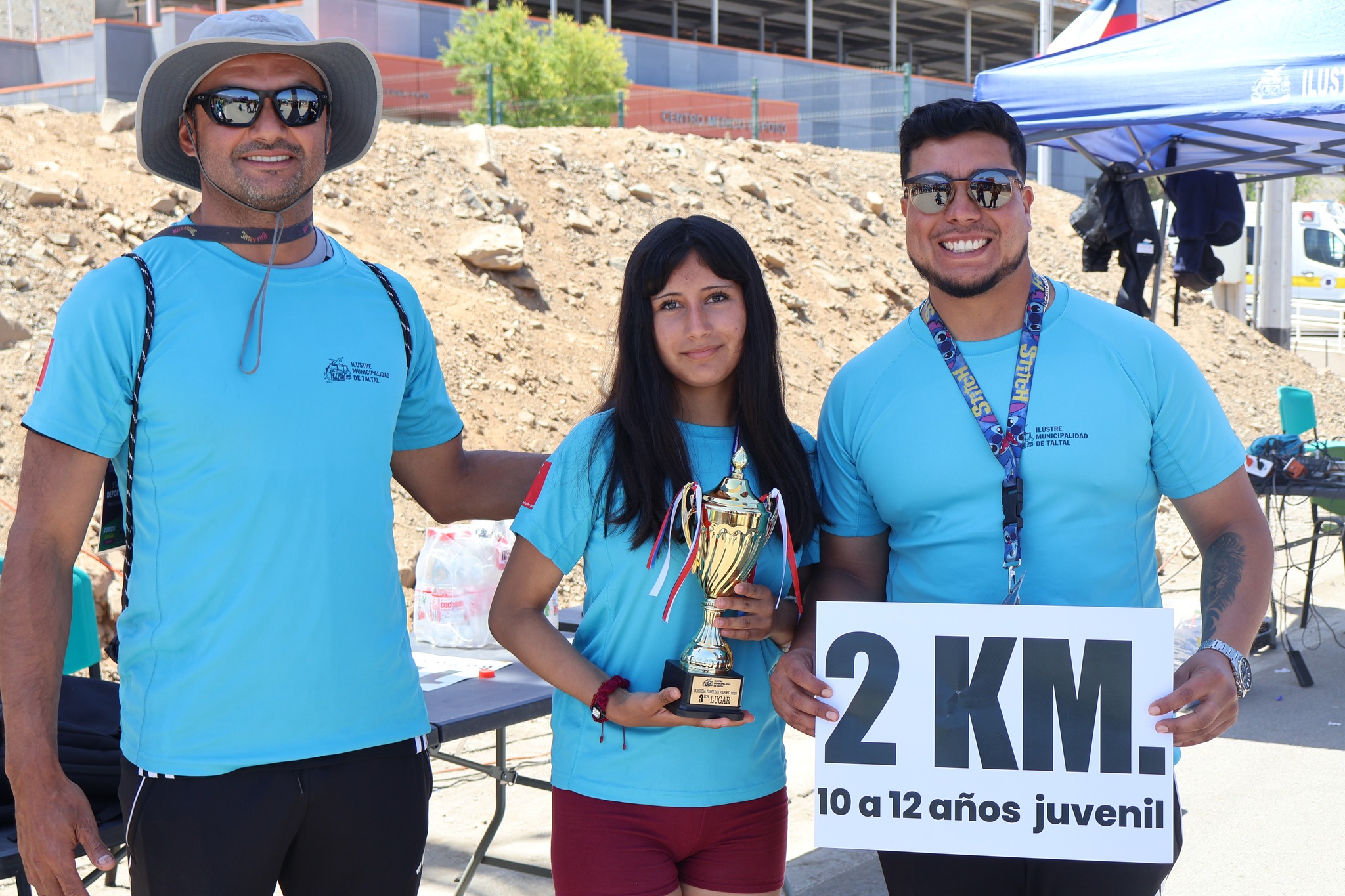 Entrega de trofeos a ganadores de la categoría juvenil 2K en la Corrida Familiar de Paposo 2025, junto a monitores del programa de deportes municipal.