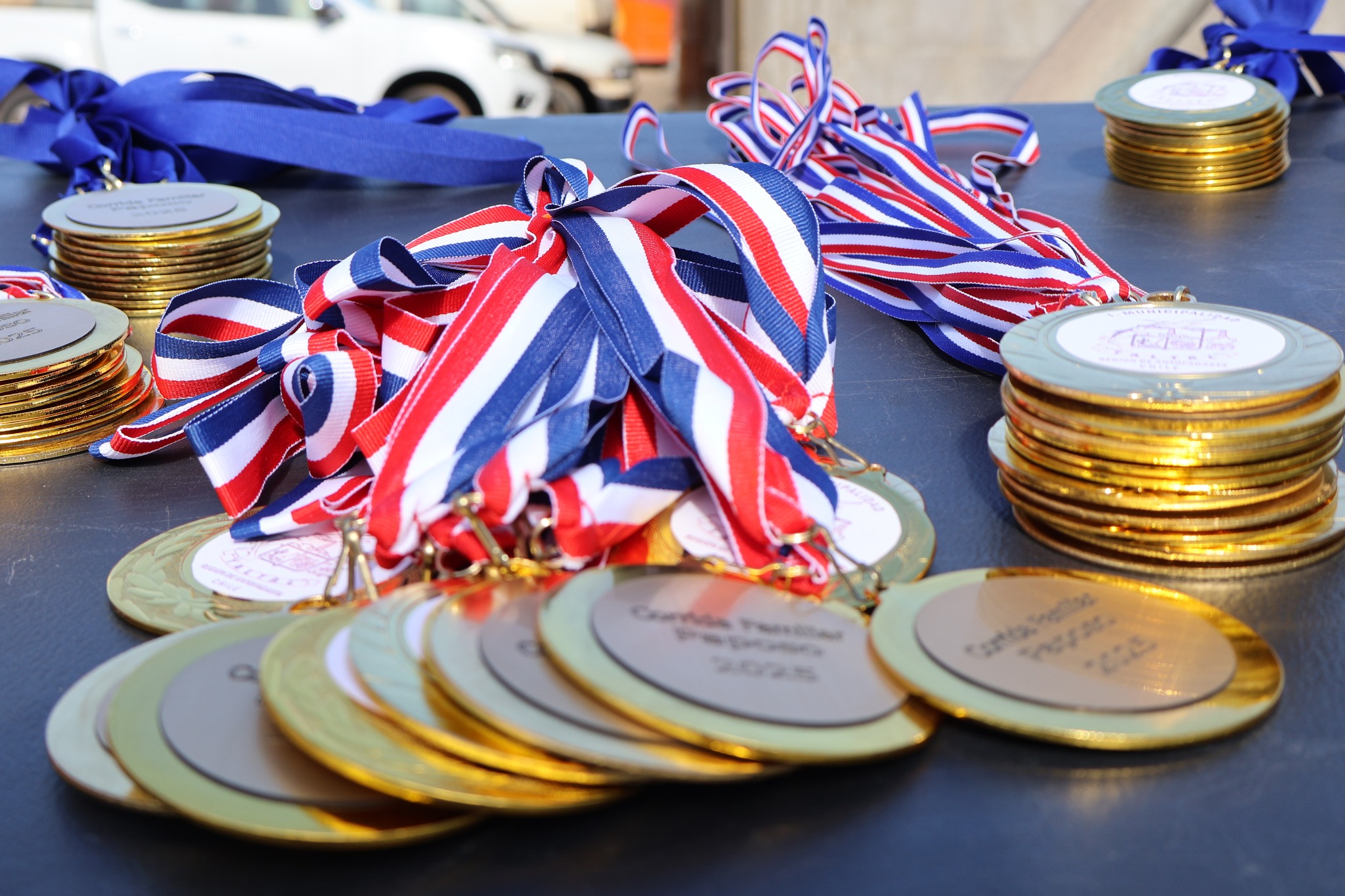 Primer plano de las medallas doradas entregadas en la Corrida Familiar de Paposo 2025, organizadas por la Municipalidad de Taltal.