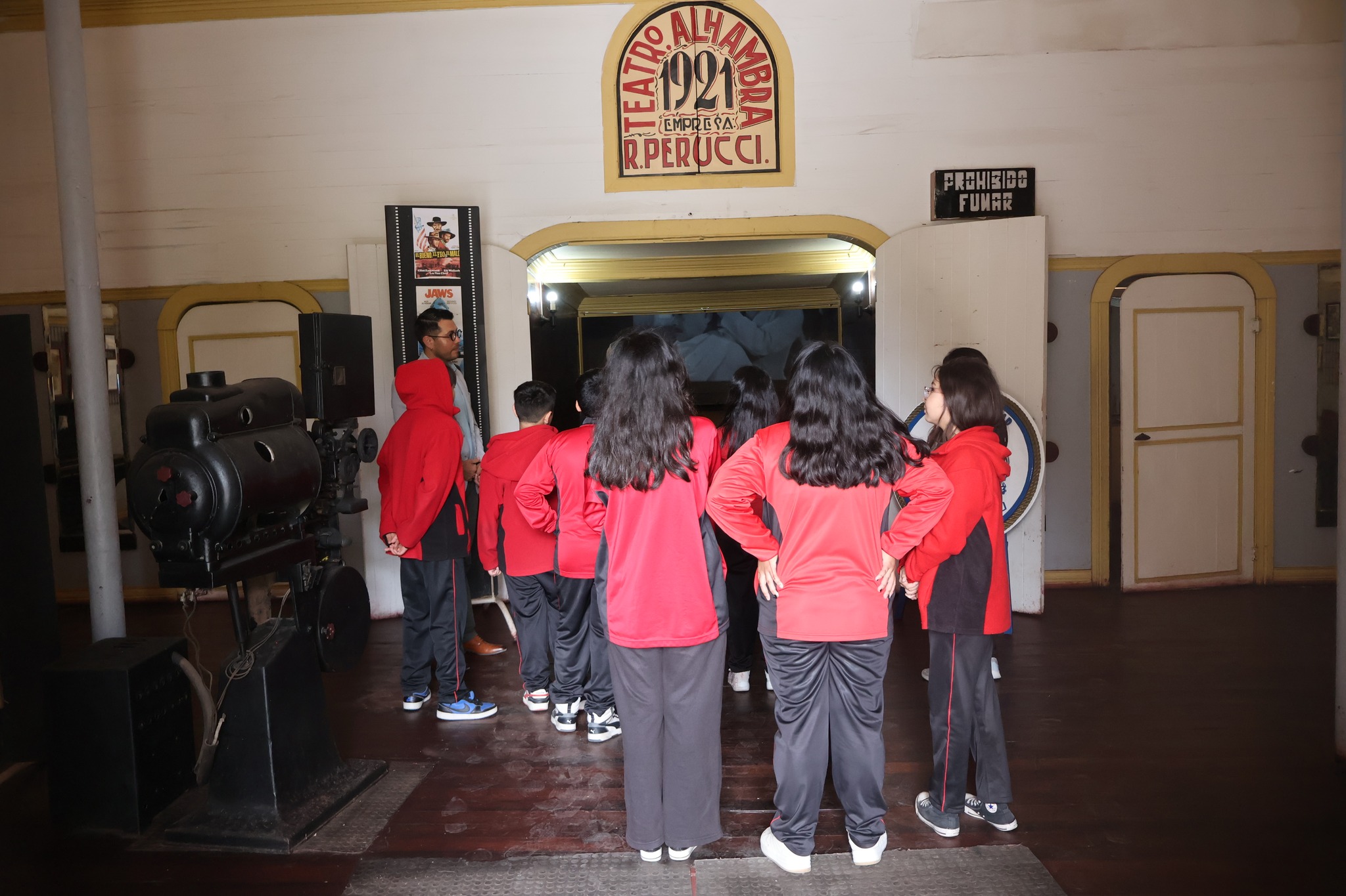 Encargado de Turismo guiando a estudiantes en el Teatro Alhambra de Taltal