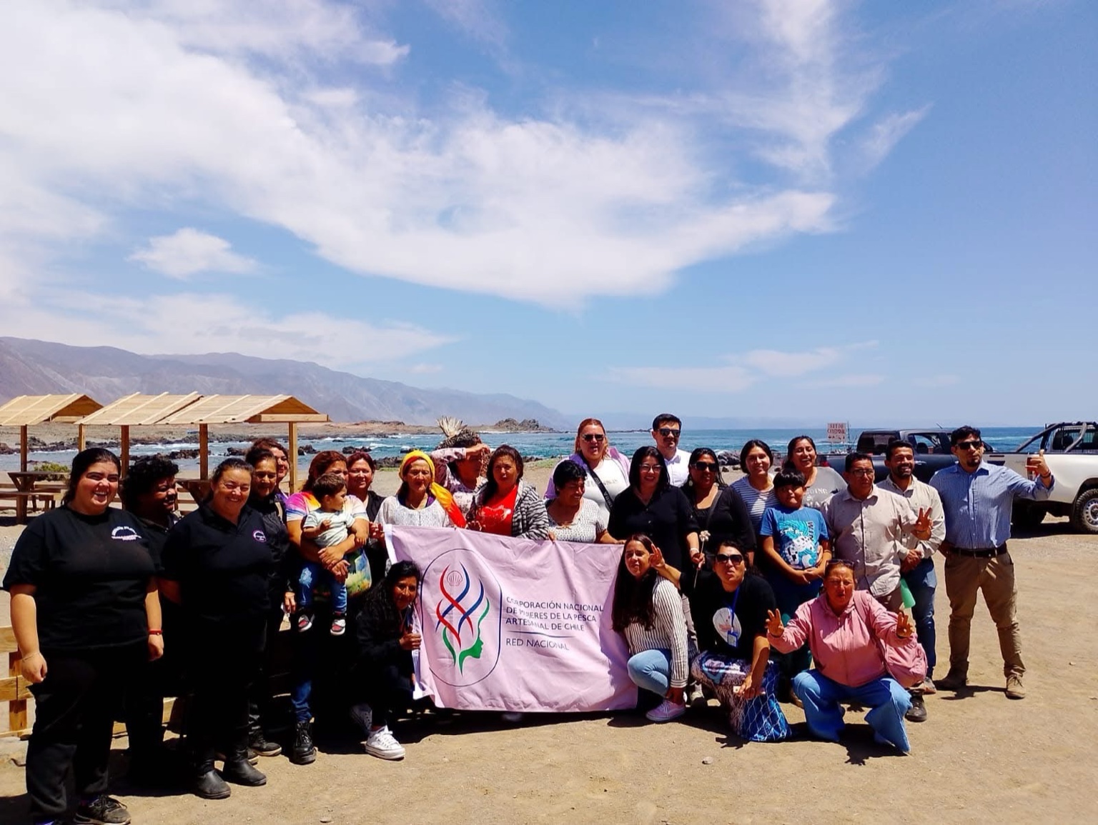 Delegadas de caletas del norte de Chile sostienen bandera de la Corporación Nacional de Mujeres de la Pesca.
