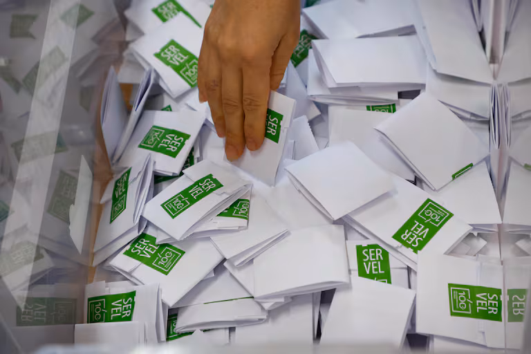 Imagen del proceso de votación del Servel para las Elecciones 2025 en Chile, con un voto ingresando a la urna.