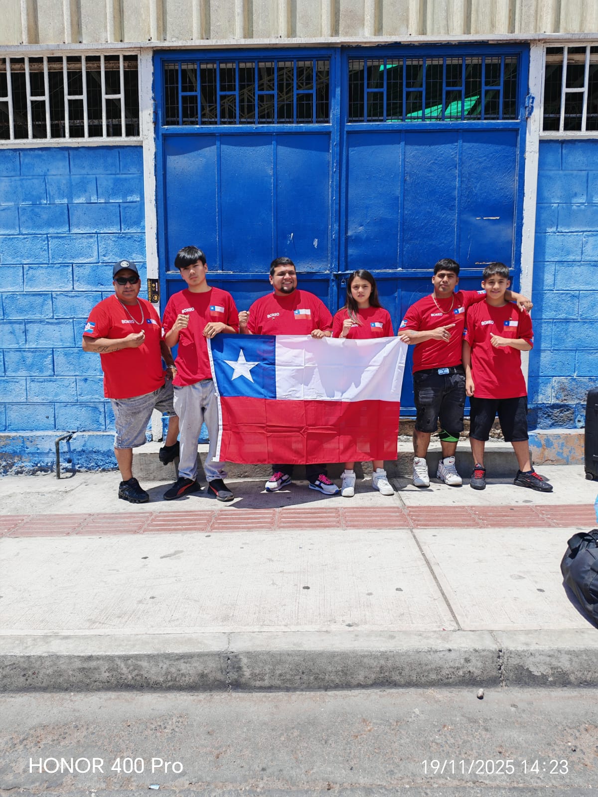 Boxeadores de Taltal posan con la bandera de Chile frente al estadio techado antes de viajar al Sudamericano ABA