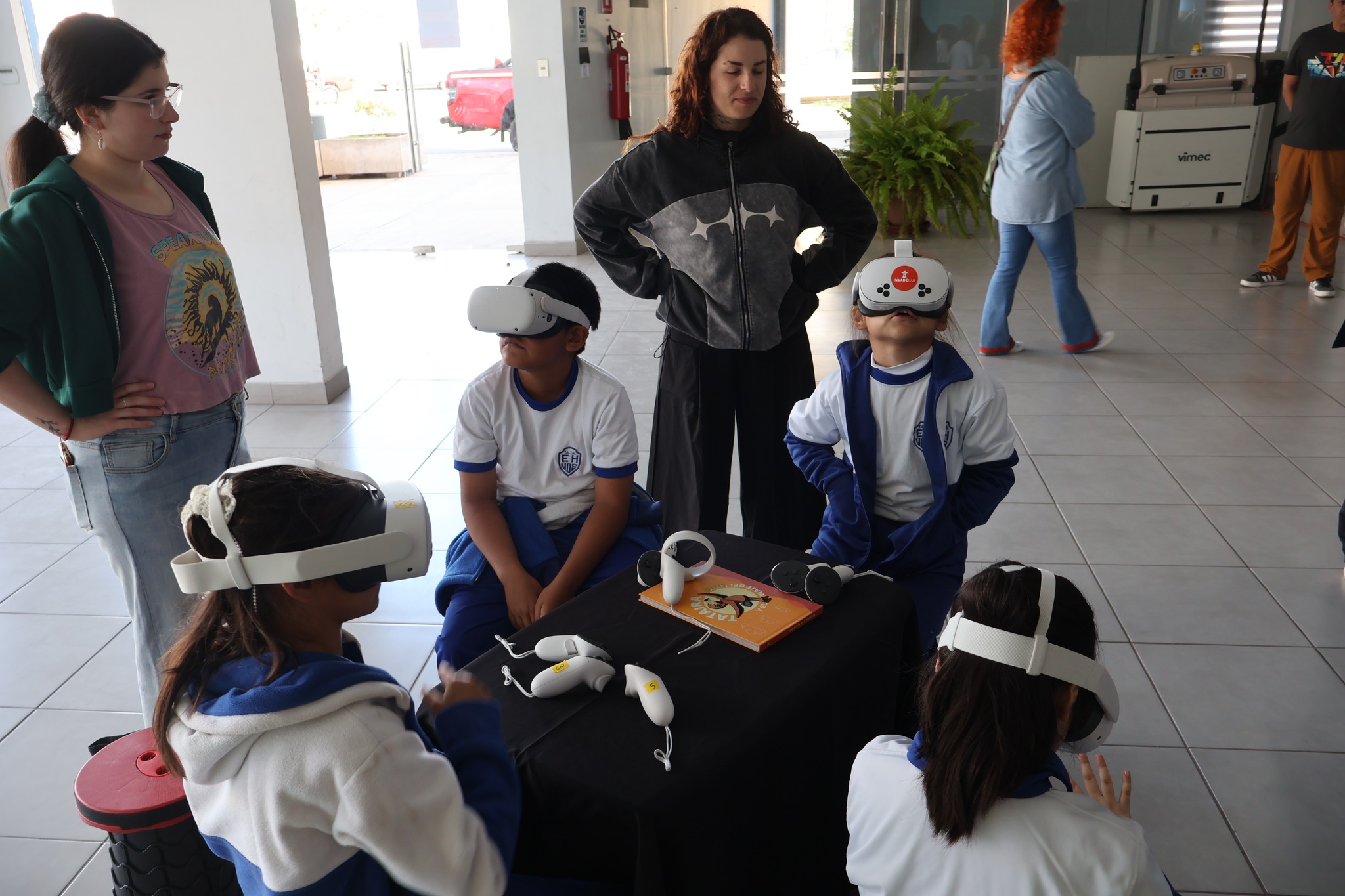 Estudiantes de Taltal usando visores de realidad virtual del proyecto Tataira, acompañados por monitoras.