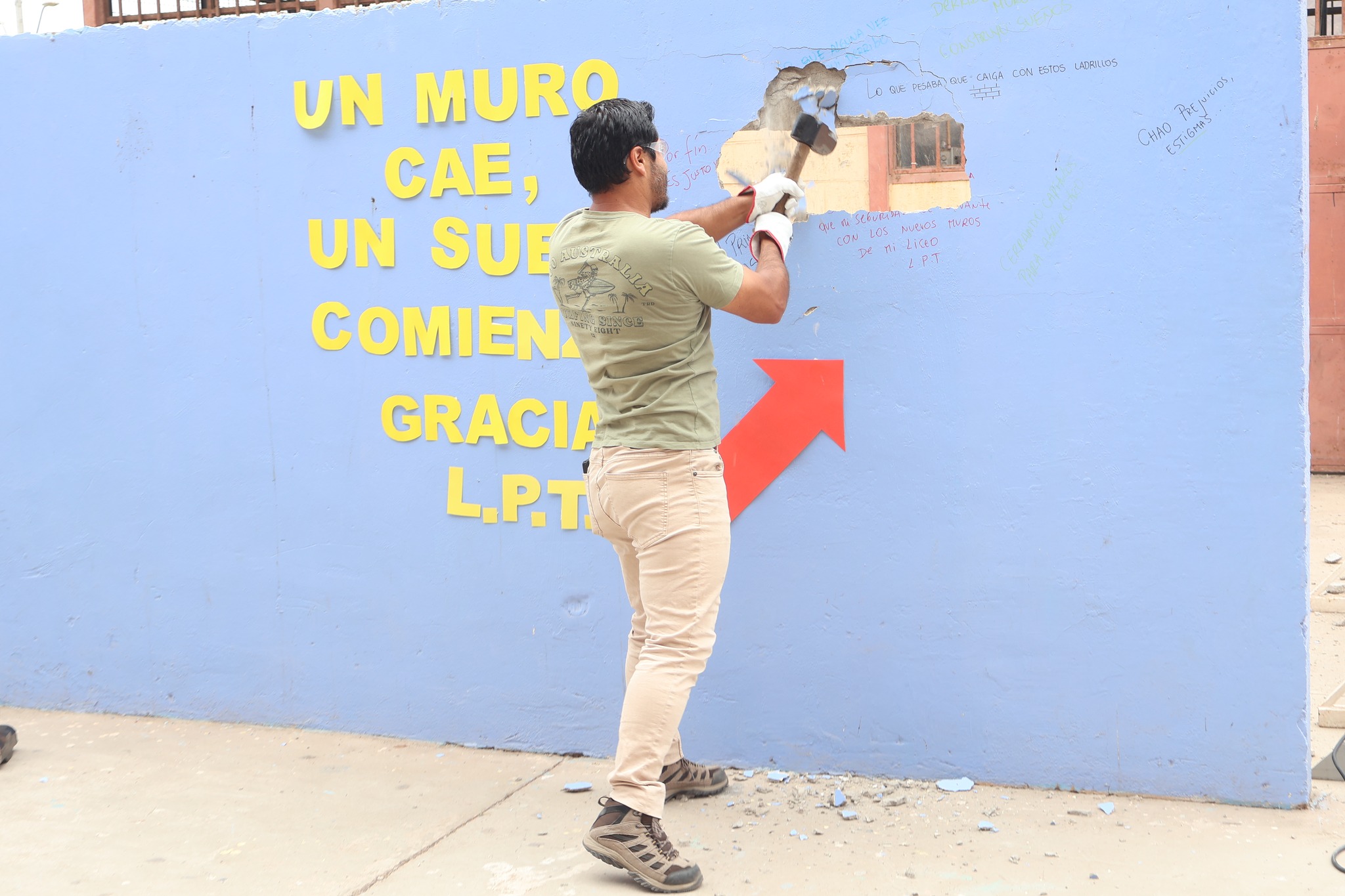 Miembro de la comunidad educativa derriba parte del muro en ceremonia del Liceo Politécnico.