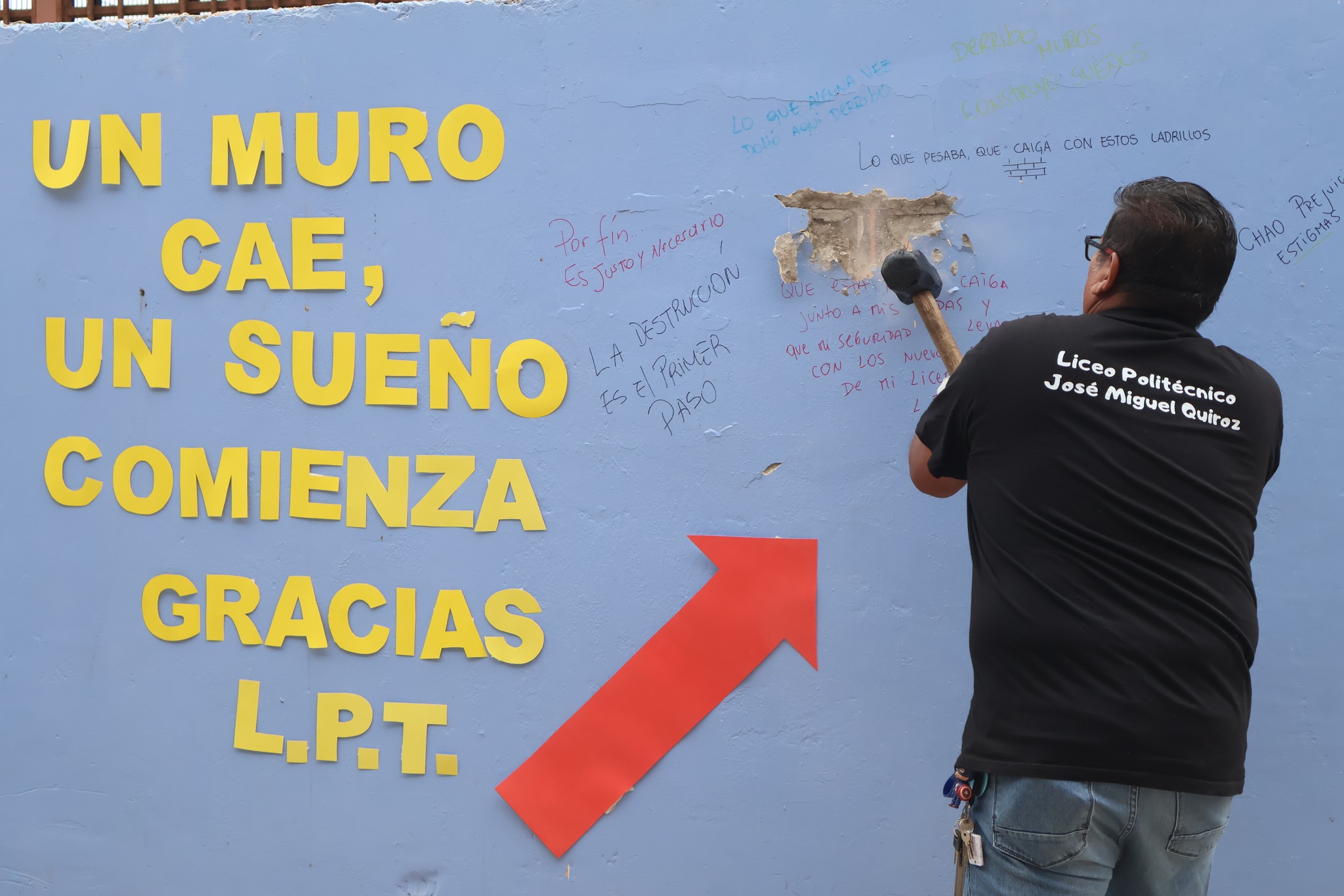 Funcionario del Liceo Politécnico José Miguel Quiroz realiza golpe simbólico al muro con mensajes escritos por estudiantes.