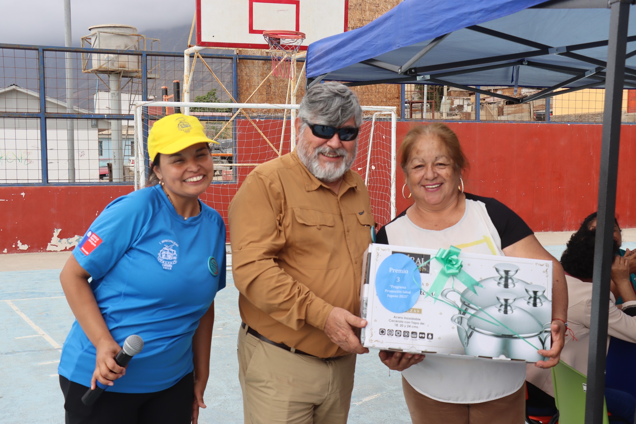 Entrega de premio mayor del Bingo Social a vecina ganadora junto a autoridades.