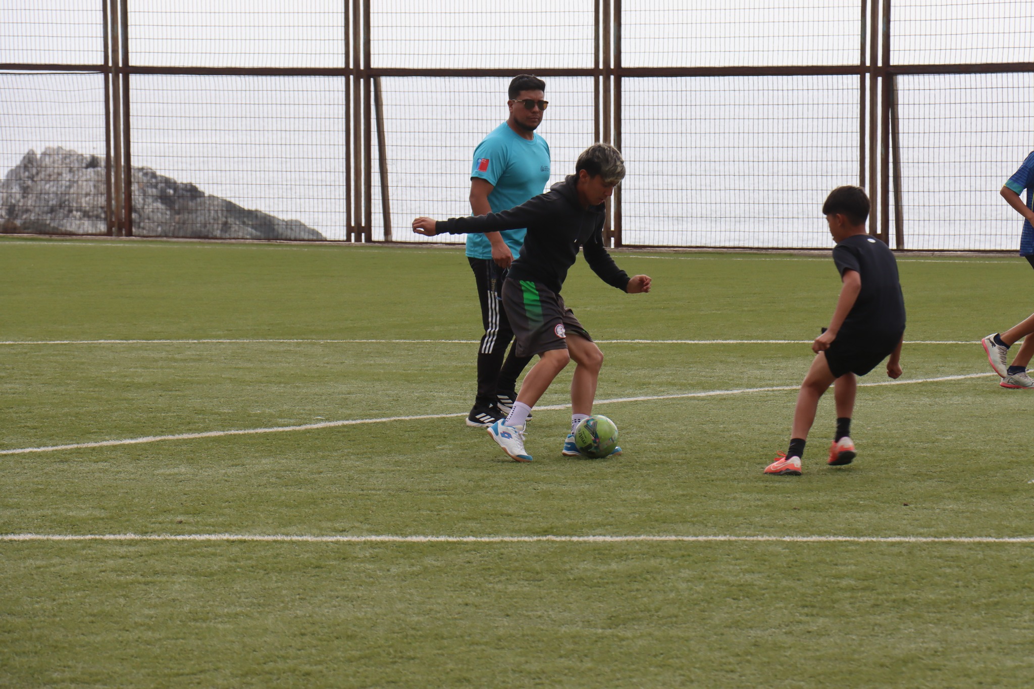 Joven realizando jugada de fútbol durante partido amistoso.