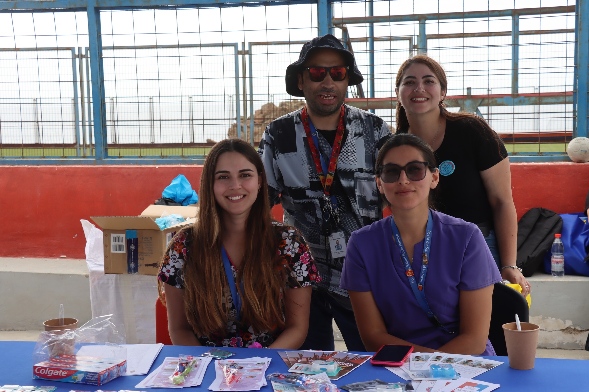 Equipo de salud rural posando junto a stand con material educativo.