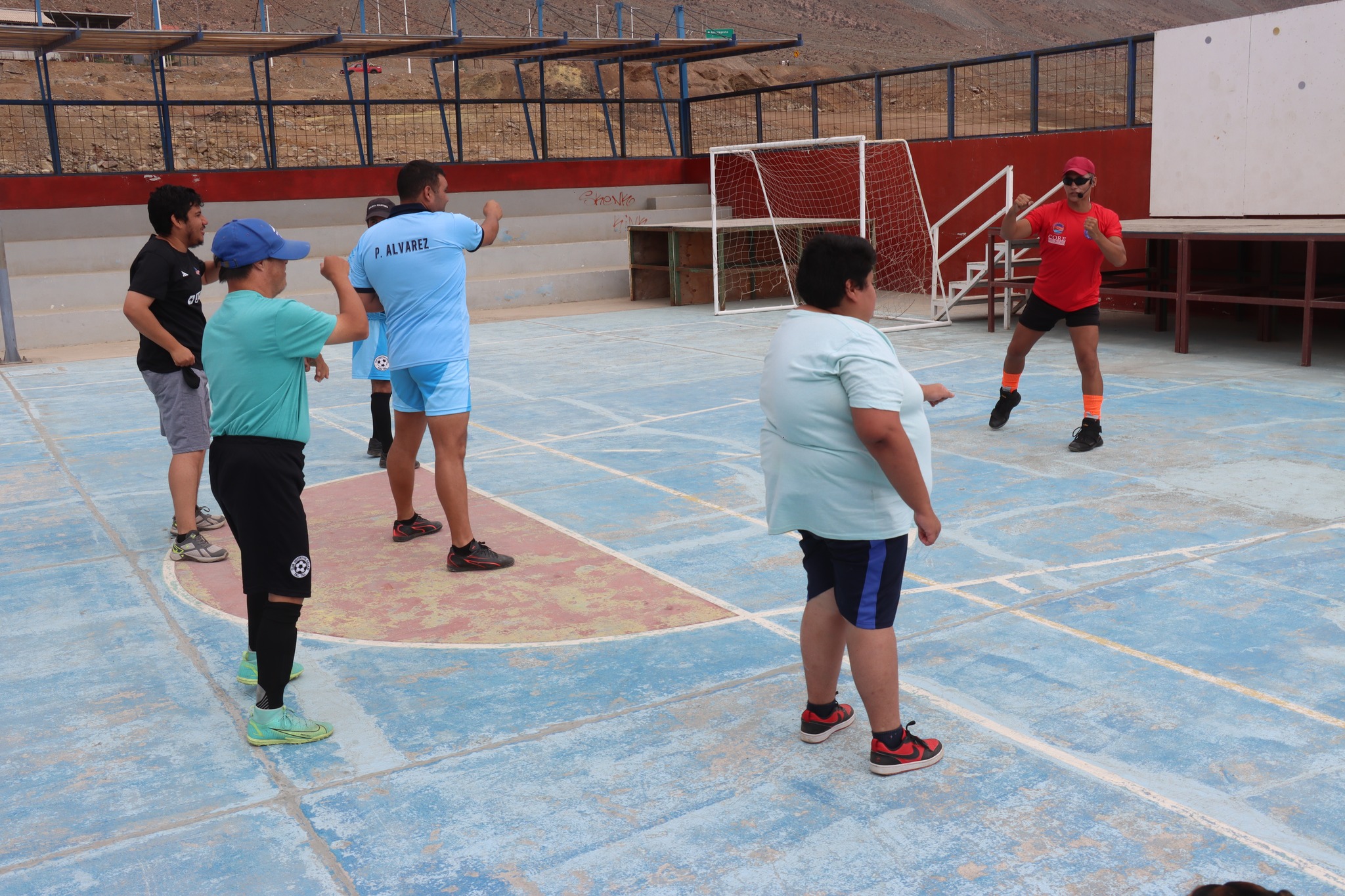 Monitor deportivo guiando calentamiento en cancha de Paposo.