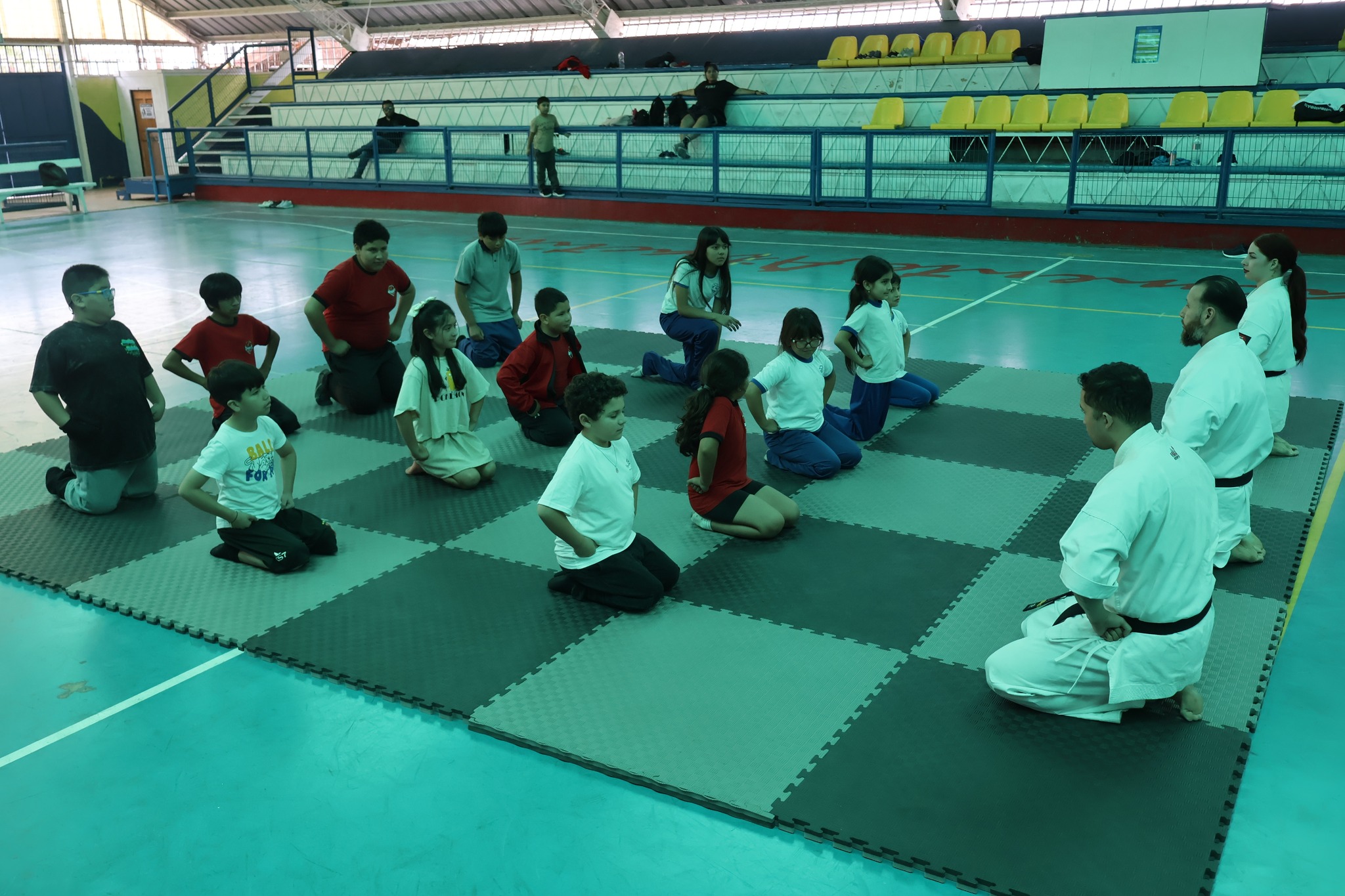 El sensei Víctor Collao entrega instrucciones a un grupo de estudiantes durante la actividad de karate en el Estadio Techado de Taltal.