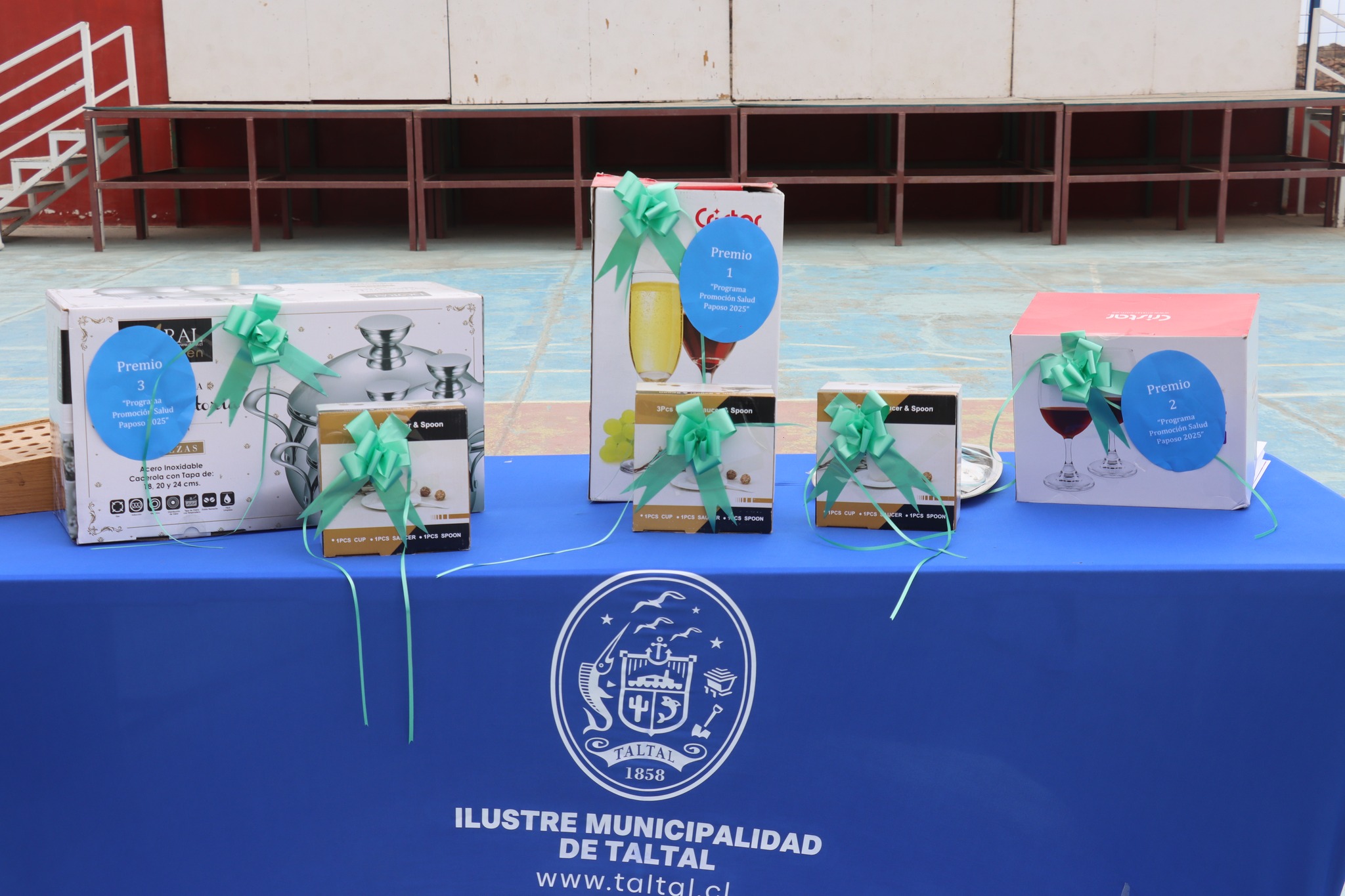 Premios del Bingo Social exhibidos sobre mesa institucional de la Municipalidad de Taltal.