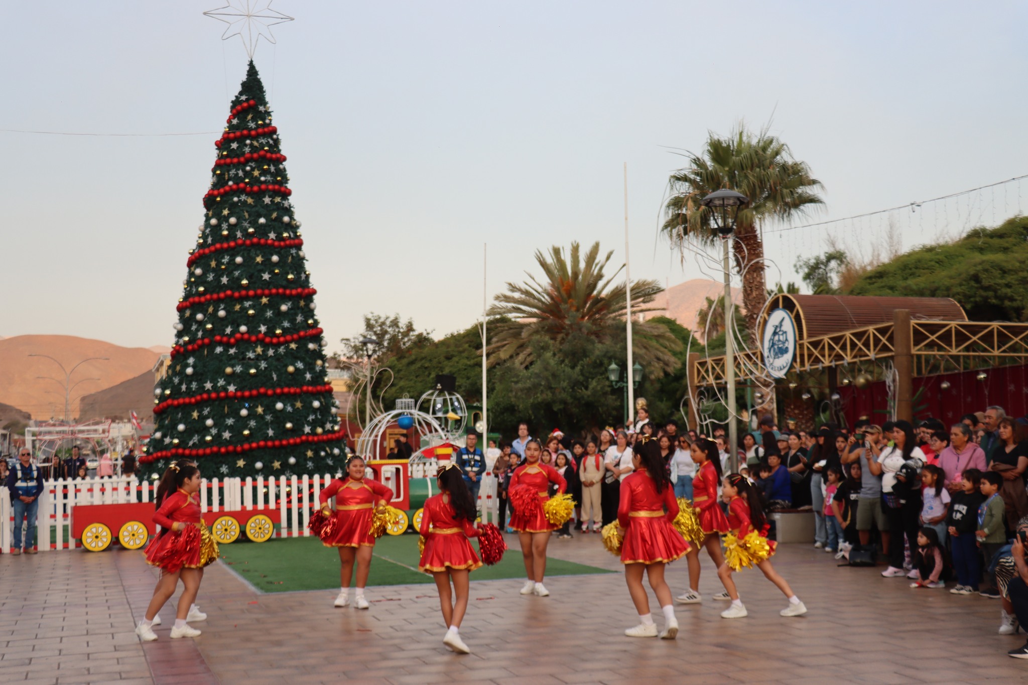 Grupo de cheerleaders infantiles realizando presentación navideña en la Plaza de Armas de Taltal