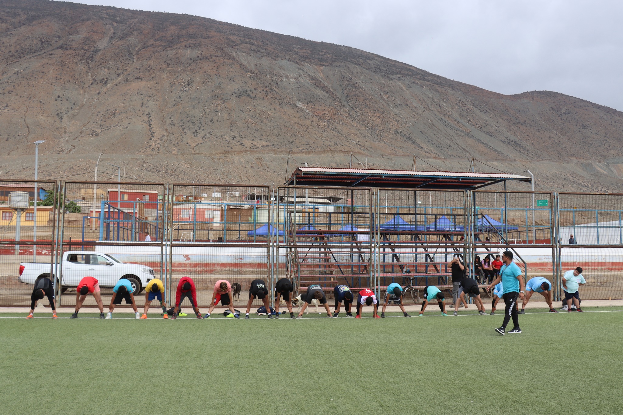 Grupo realizando ejercicios de elongación guiados por monitor.