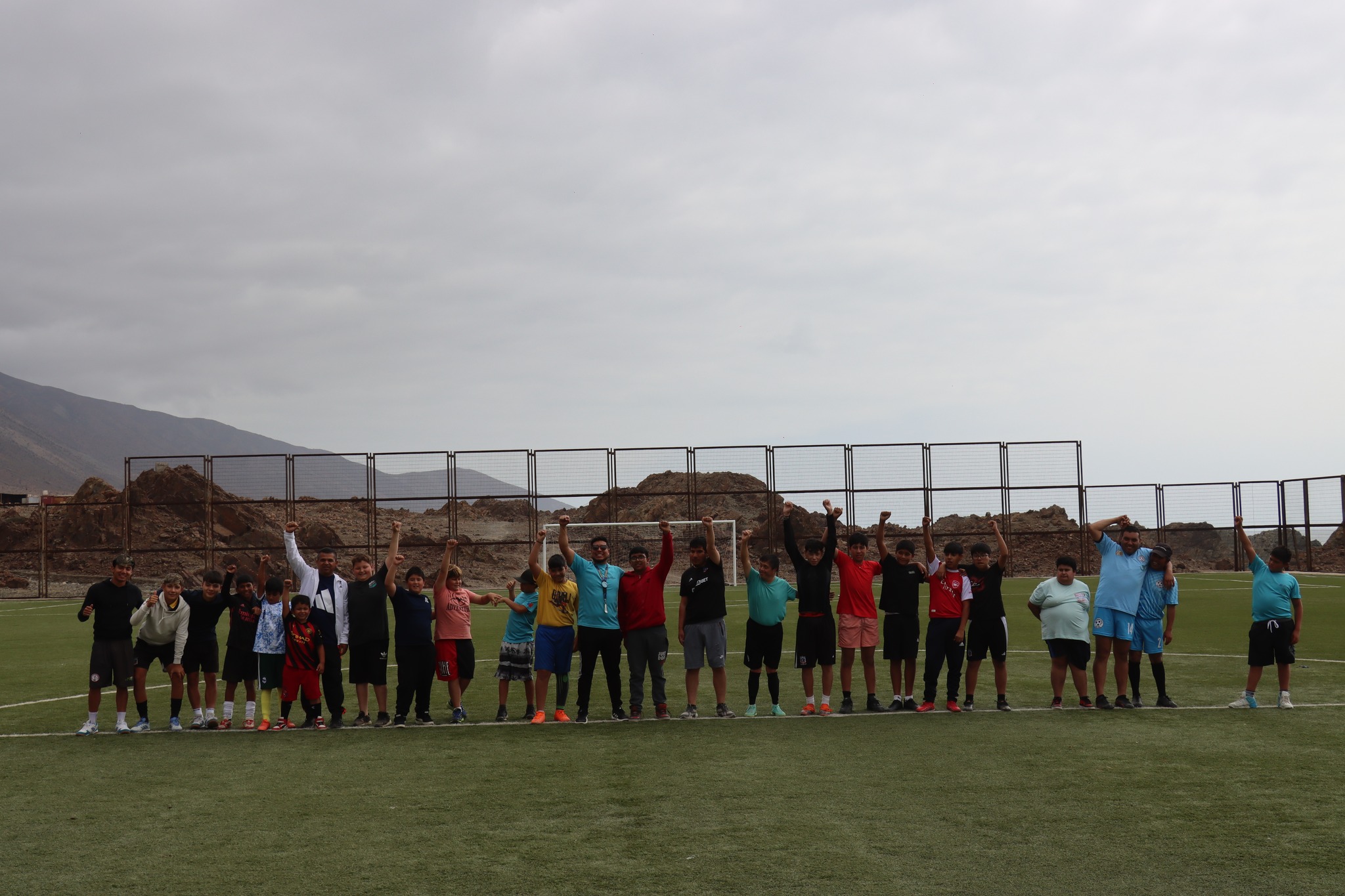 paposo-13.jpg<br />
Foto grupal de participantes del fútbol levantando manos tras la actividad.