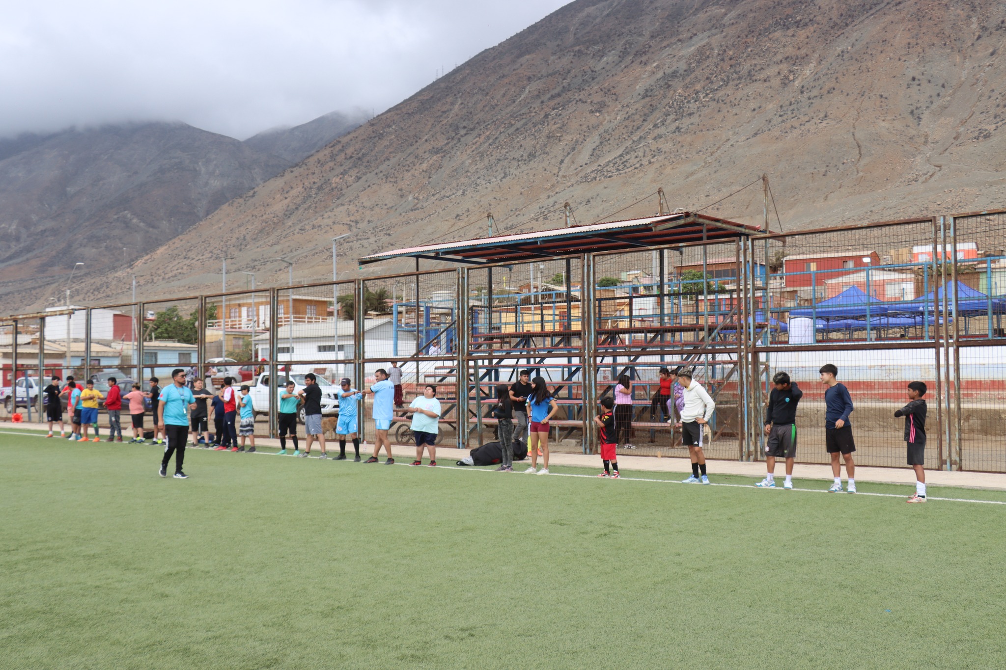 Participantes en fila realizando ejercicios de calentamiento en la cancha.