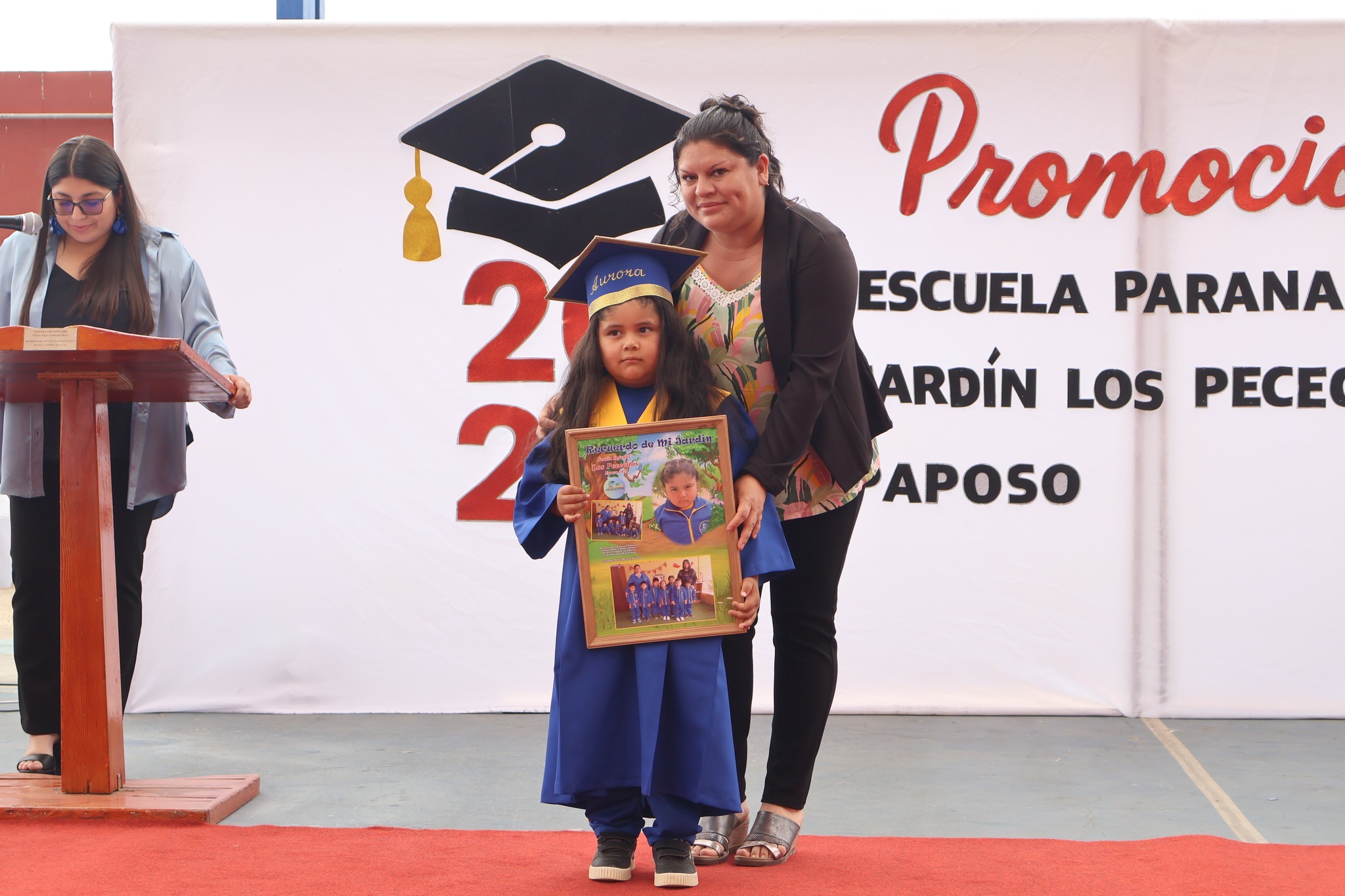 Aurora recibe su recuerdo de licenciatura del Jardín Infantil Los Pececitos durante ceremonia 2025 en la Escuela Paranal de Paposo.