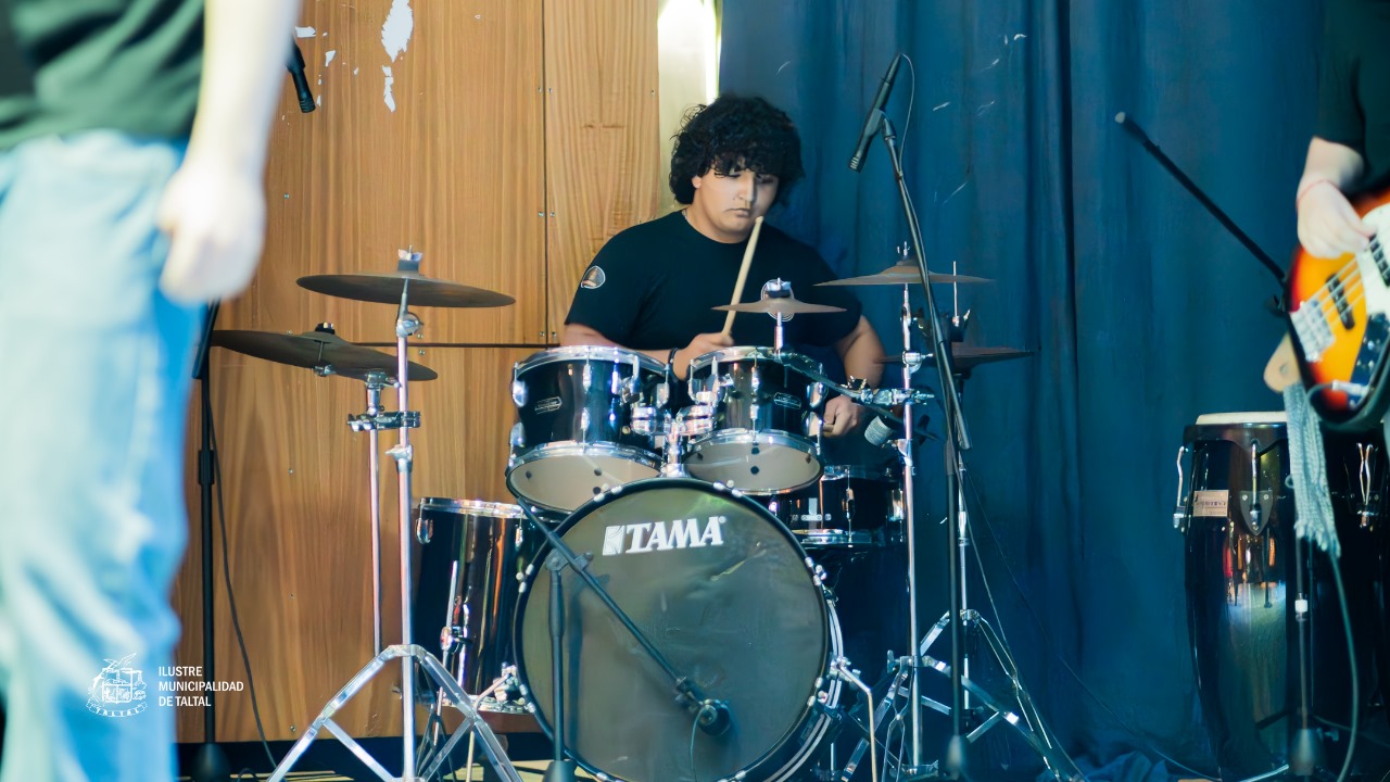 Primer plano de un joven baterista concentrado tocando la batería marca Tama.