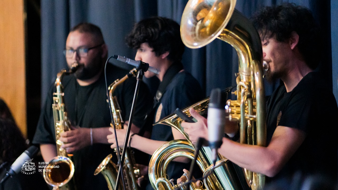 Primer plano de músicos tocando saxofones y tubas o bombardinos en el ensamble instrumental.