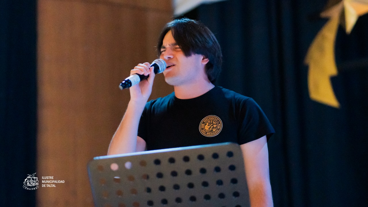 Primer plano de un joven solista del Taller de Canto interpretando una canción en un micrófono.