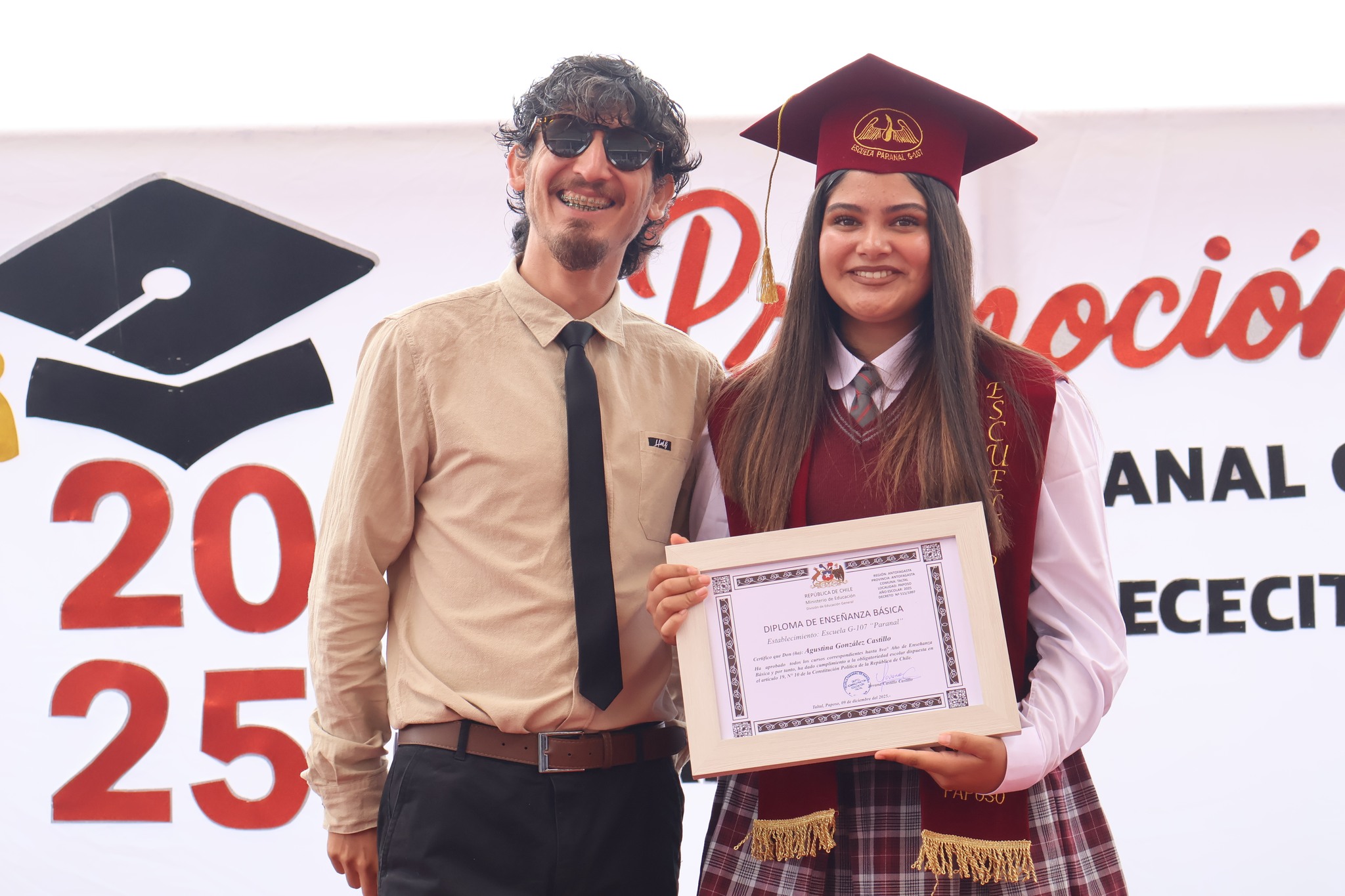 Docente entrega recuerdo institucional a estudiante durante la licenciatura de la Escuela Paranal de Paposo 2025.