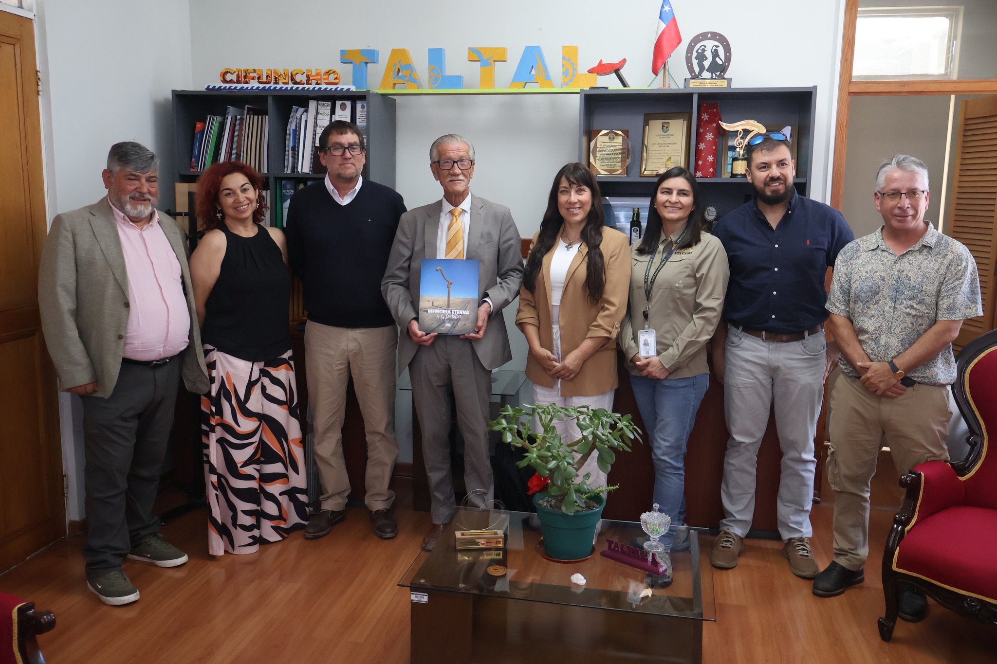 Autoridades municipales de Taltal y representantes de Atacama Mineral posan en oficina municipal junto al libro ‘Cantón Aguas Blancas, Memoria Eterna de la Pampa’