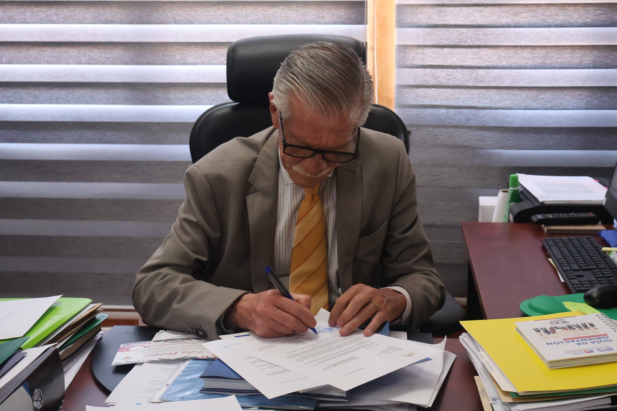 Autoridad firma documentación durante encuentro institucional con foco cultural y patrimonial en Taltal.