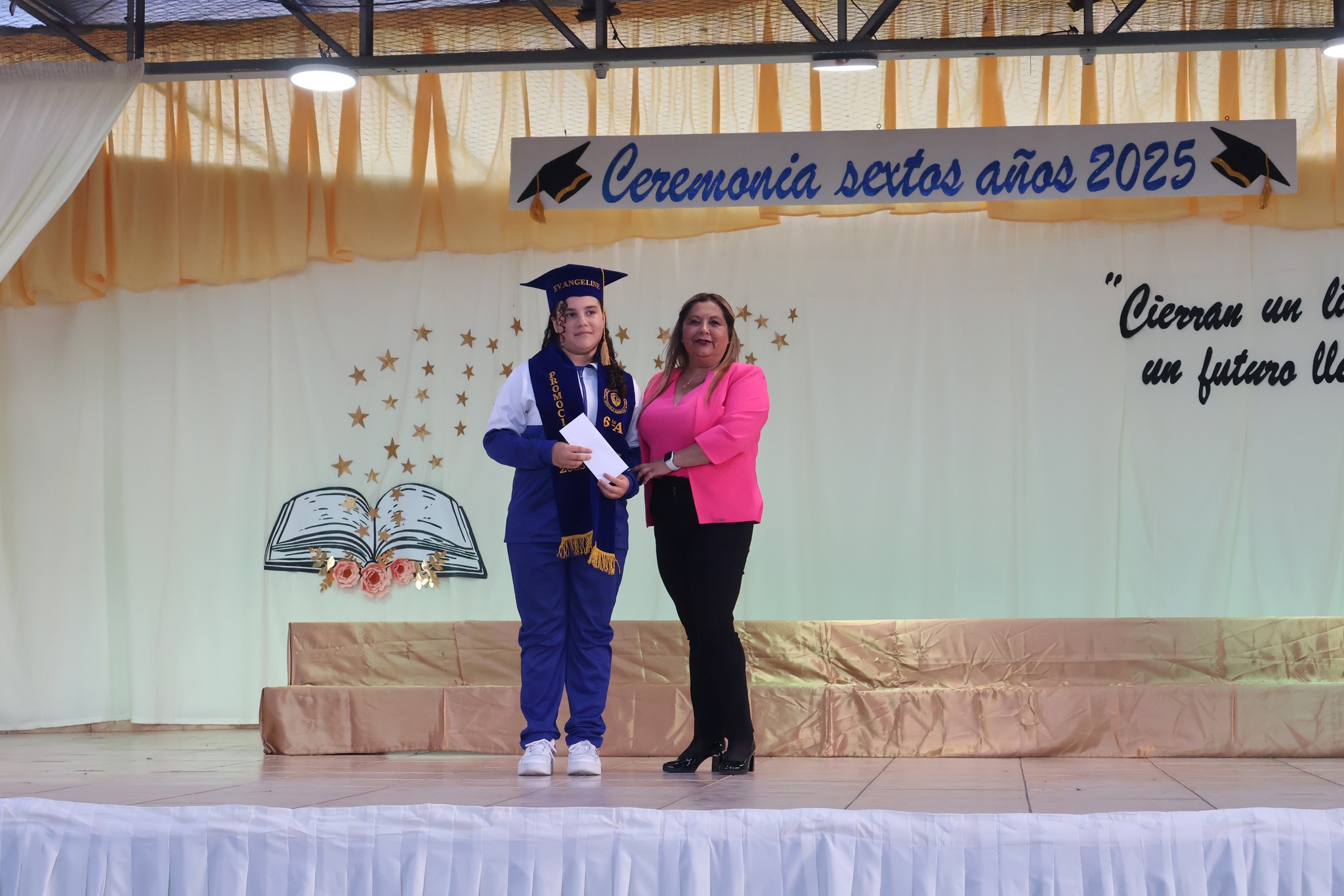 Estudiante posa con apoderada durante entrega simbólica en ceremonia escolar 2025.